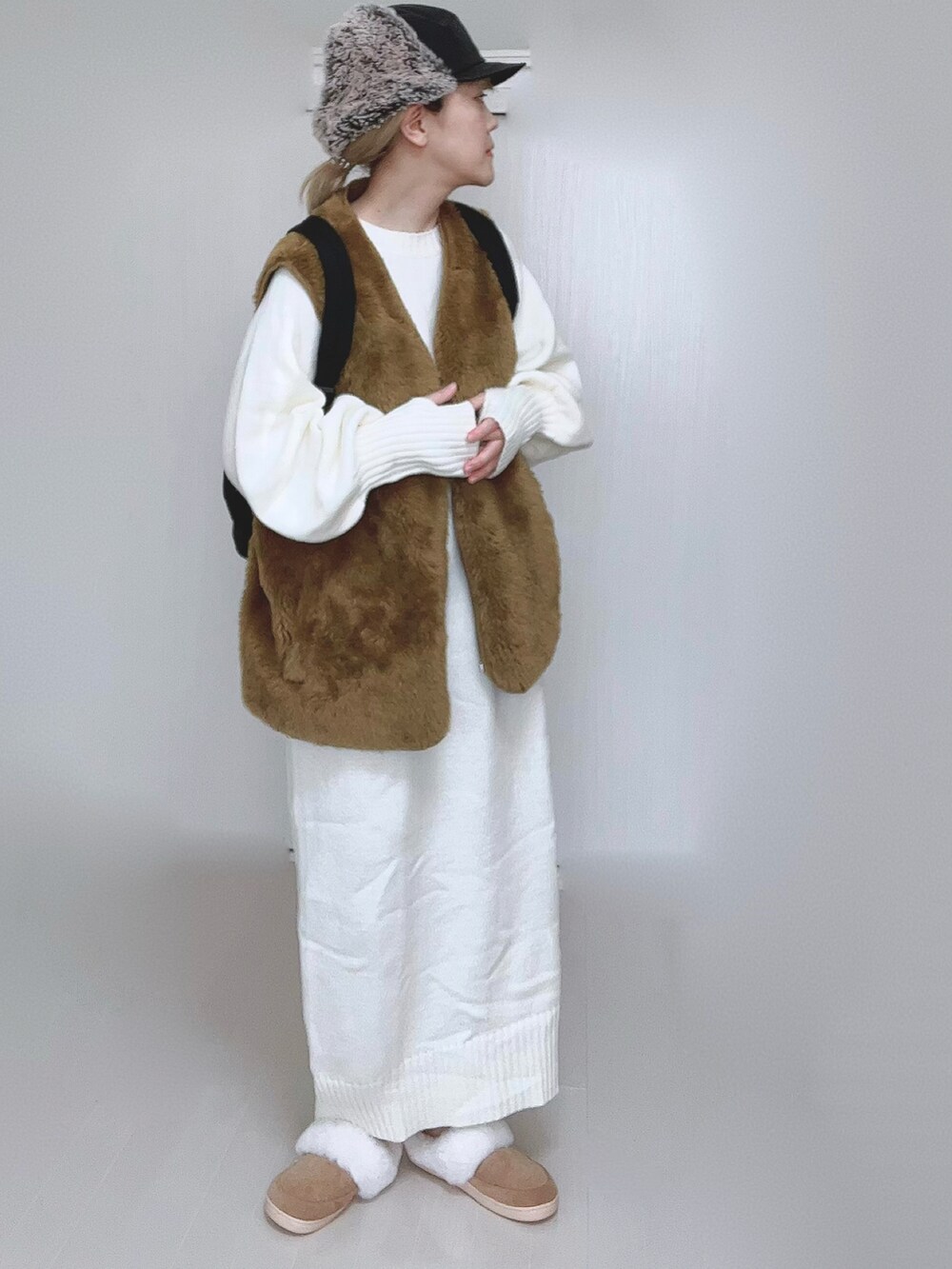 ホワイト系のワンピース、イエロー系のベスト、ブラック系のバックパック/リュックを着用したレディースの冬コーディネートの4枚目の写真