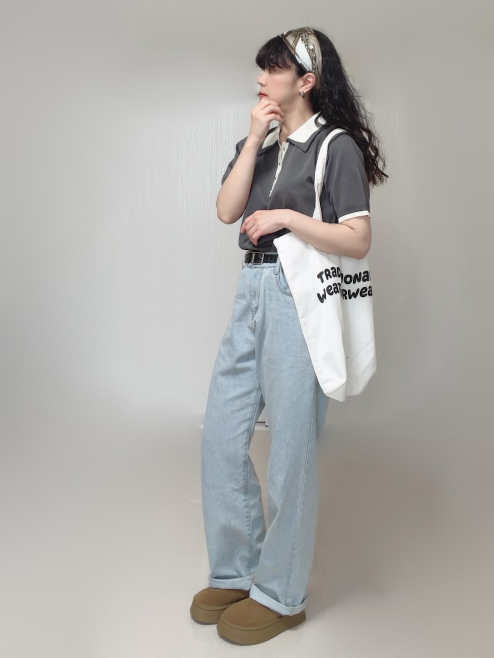 グレー系のポロシャツ、ブルー系のデニムパンツ、ホワイト系のトートバッグを着用したレディースの夏コーディネートの3枚目の写真