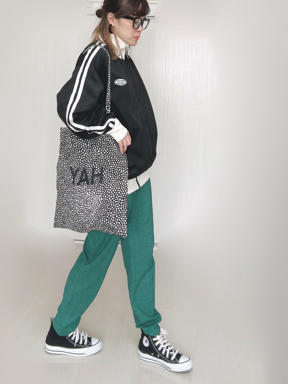 ブラック系のブルゾン、グリーン系のその他パンツ、ブラック系のスニーカーを着用したレディースの秋コーディネートの3枚目の写真