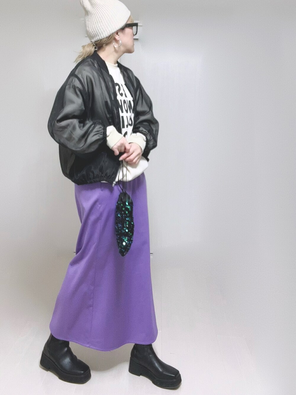 パープル系のスカート、ブラック系のブーツを着用したレディースの冬コーディネートの3枚目の写真