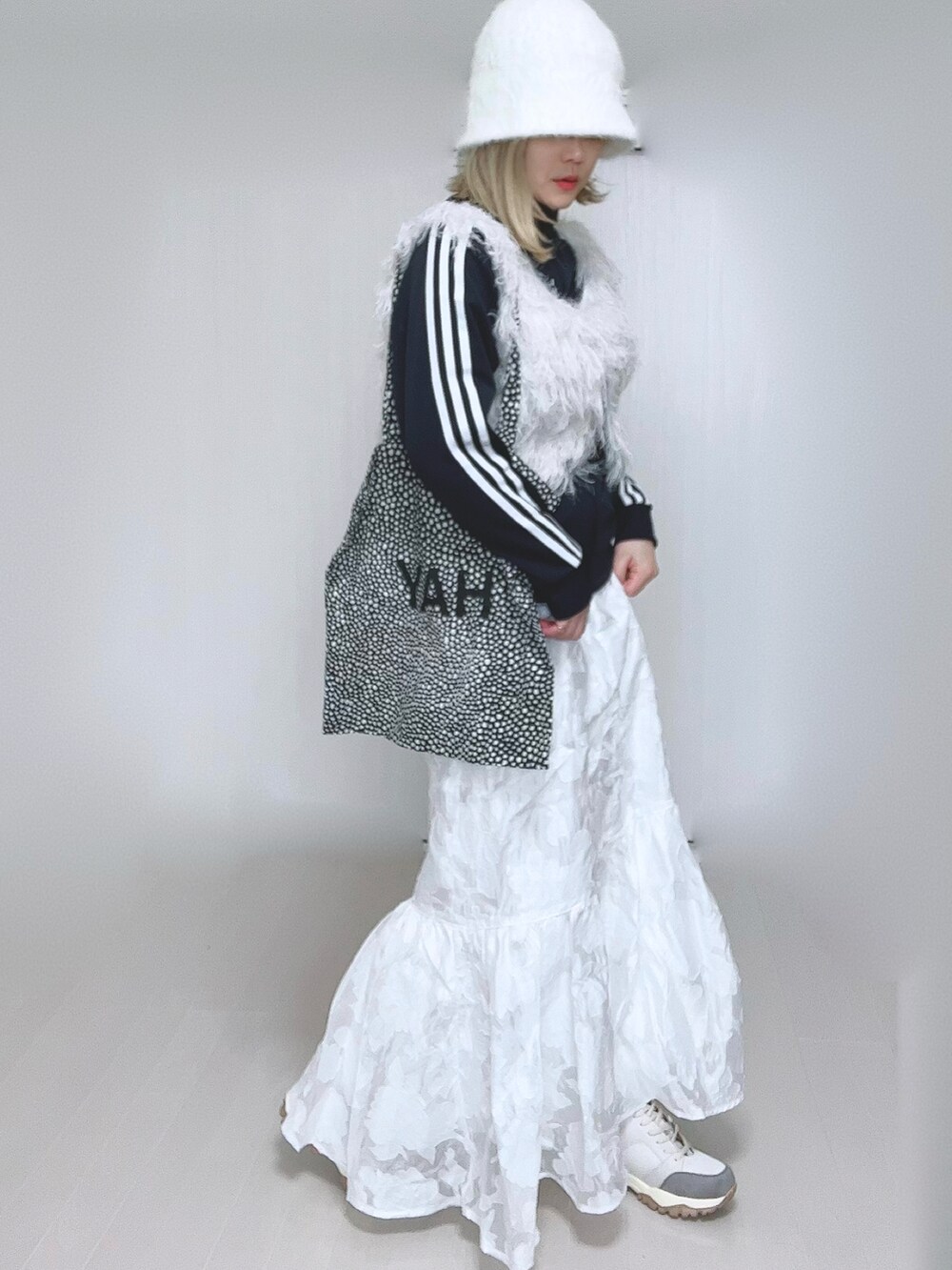 ホワイト系のベスト、ブルー系のナイロンジャケット、ホワイト系のスカートを着用したレディースの冬コーディネートの4枚目の写真