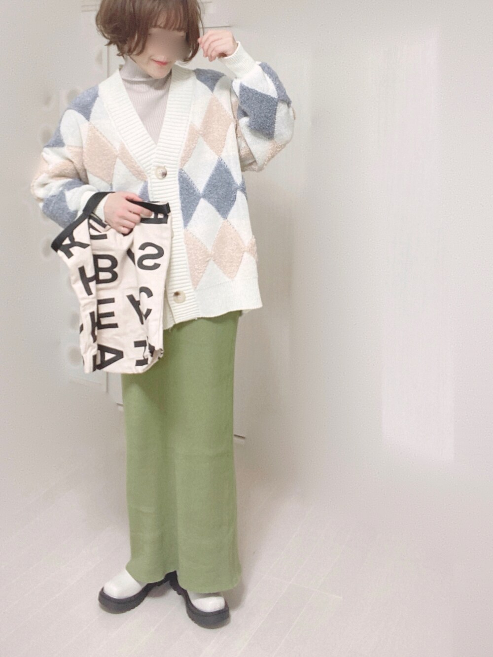 グリーン系のスカート、ホワイト系のブーツ、ホワイト系のトートバッグを着用したレディースの冬コーディネートの3枚目の写真