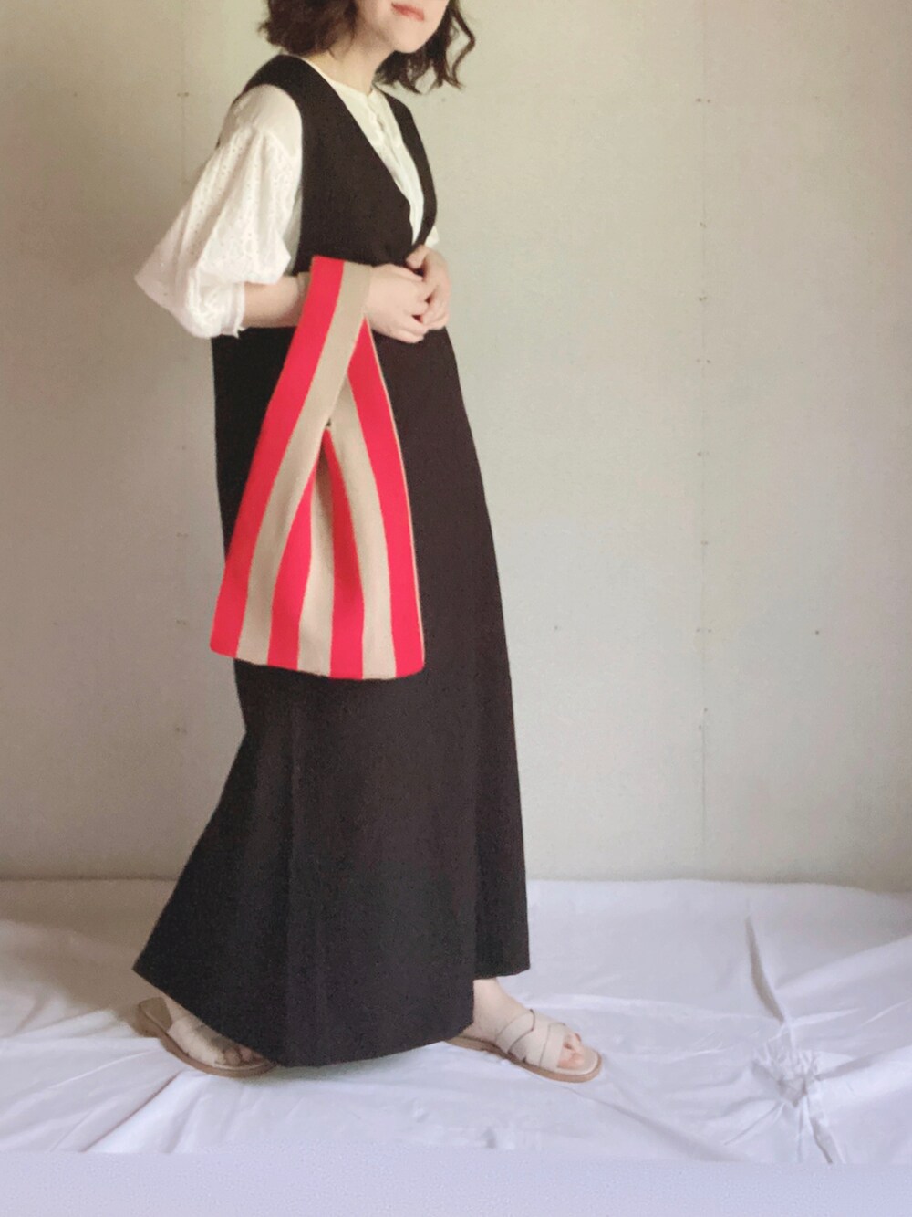 ブラック系のワンピース、ホワイト系のシャツ/ブラウス、ホワイト系のサンダルを着用したレディースの夏コーディネートの2枚目の写真