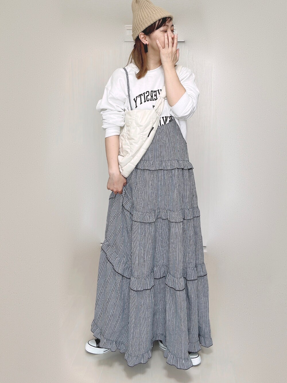 ホワイト系のスウェット、ホワイト系のショルダーバッグ、ブラック系のワンピースを着用したレディースの秋コーディネートの5枚目の写真