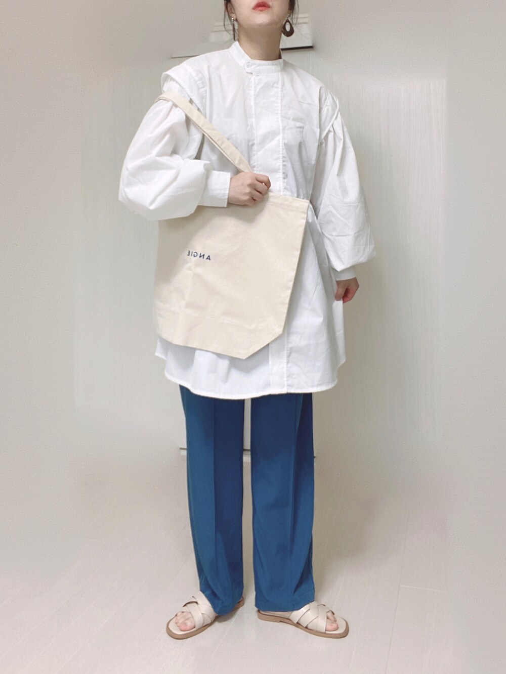 ブルー系のその他パンツ、ホワイト系のトートバッグ、ホワイト系のチュニックを着用したレディースの春コーディネートの3枚目の写真