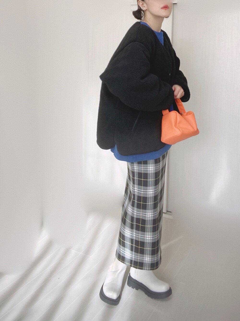 ブラック系のブルゾン、ブルー系のスウェット、ブラック系のスカートを着用したレディースの冬コーディネートの2枚目の写真