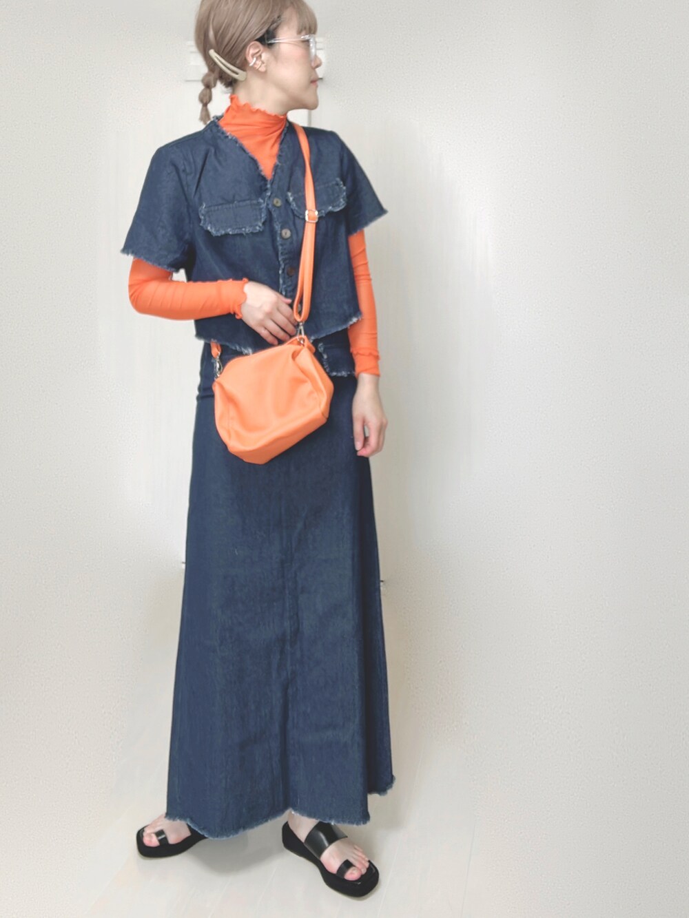 オレンジ系のTシャツ/カットソー、ブルー系のセットアップ、オレンジ系のショルダーバッグを着用したレディースの秋コーディネートの2枚目の写真