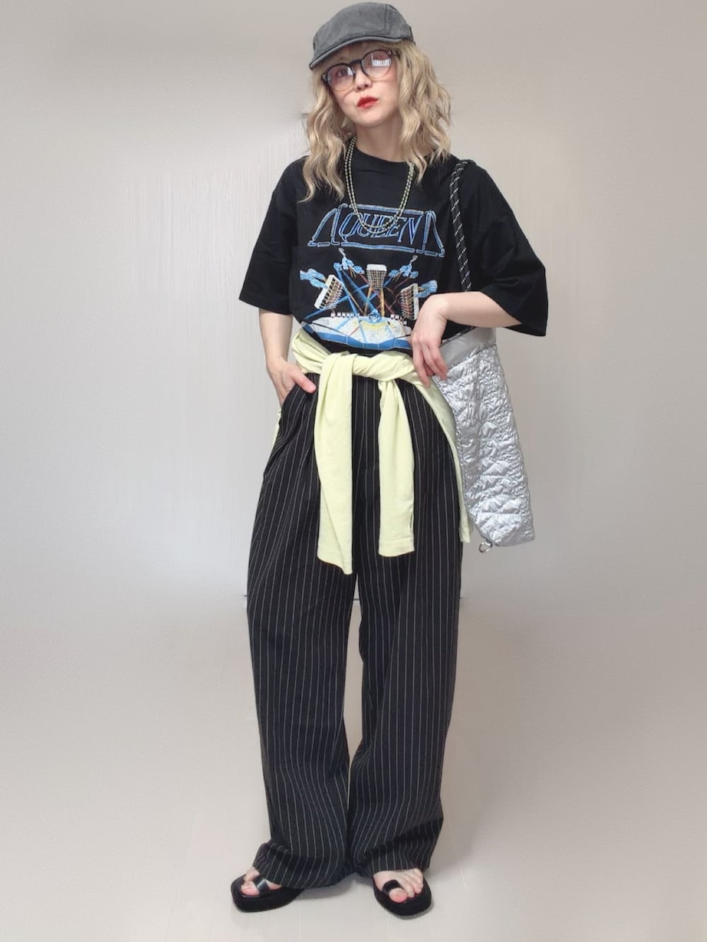シルバー系のトートバッグ、ブラック系のサンダル、イエロー系のTシャツ/カットソーを着用したレディースの夏コーディネートの2枚目の写真