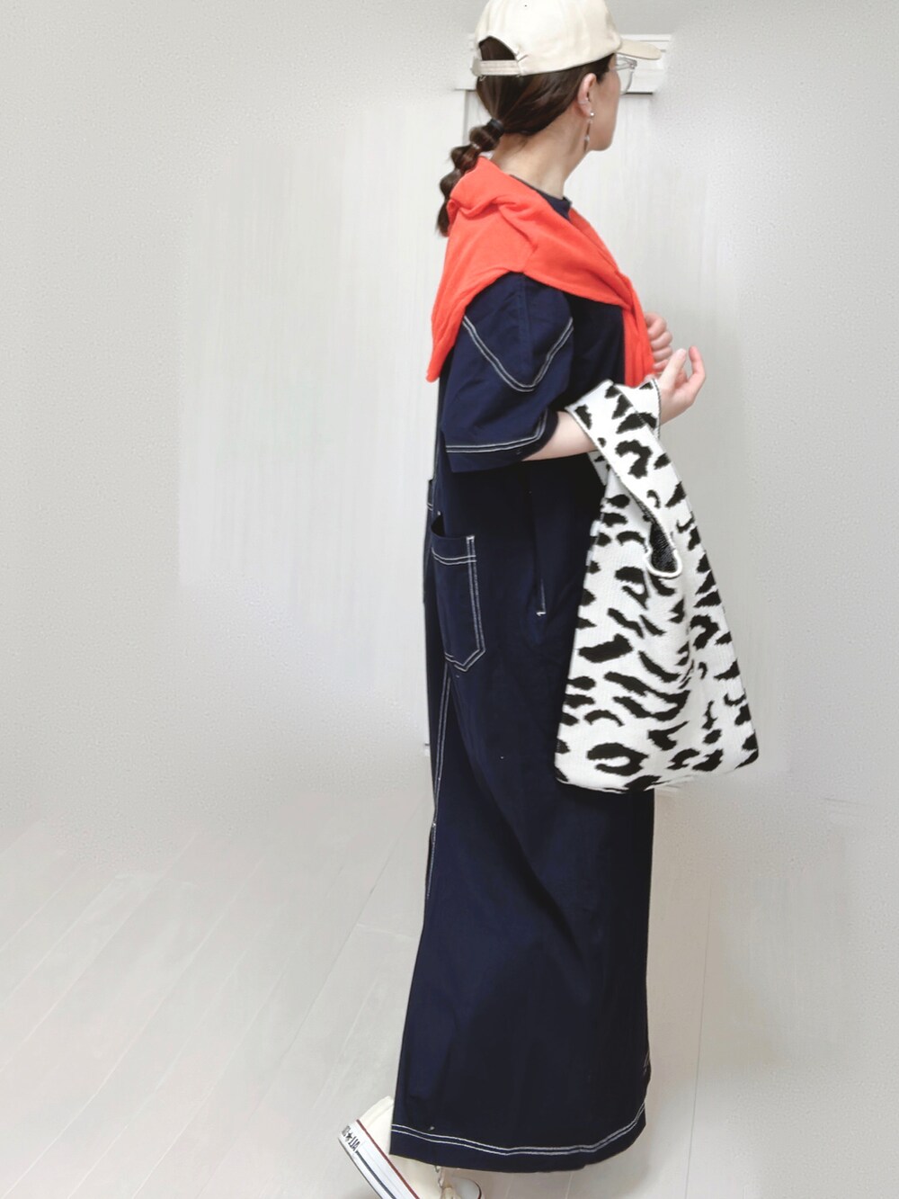 ブルー系のワンピース、オレンジ系のカーディガン/ボレロ、ホワイト系のスニーカーを着用したレディースの春コーディネートの5枚目の写真