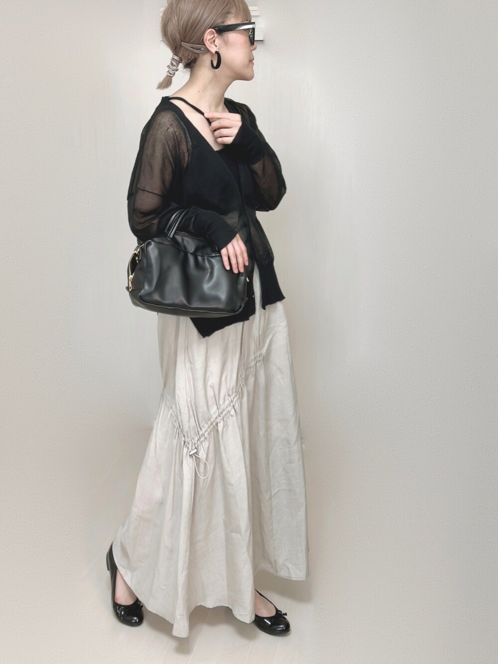 ブラック系のカーディガン/ボレロ、ブラック系のキャミソール、ブラック系のボストンバッグを着用したレディースの夏コーディネートの5枚目の写真