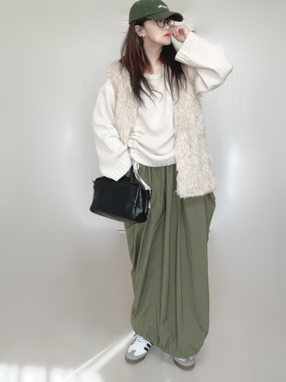 ホワイト系のニット/セーター、ホワイト系のベスト、ブラック系のボストンバッグを着用したレディースの秋コーディネートの2枚目の写真