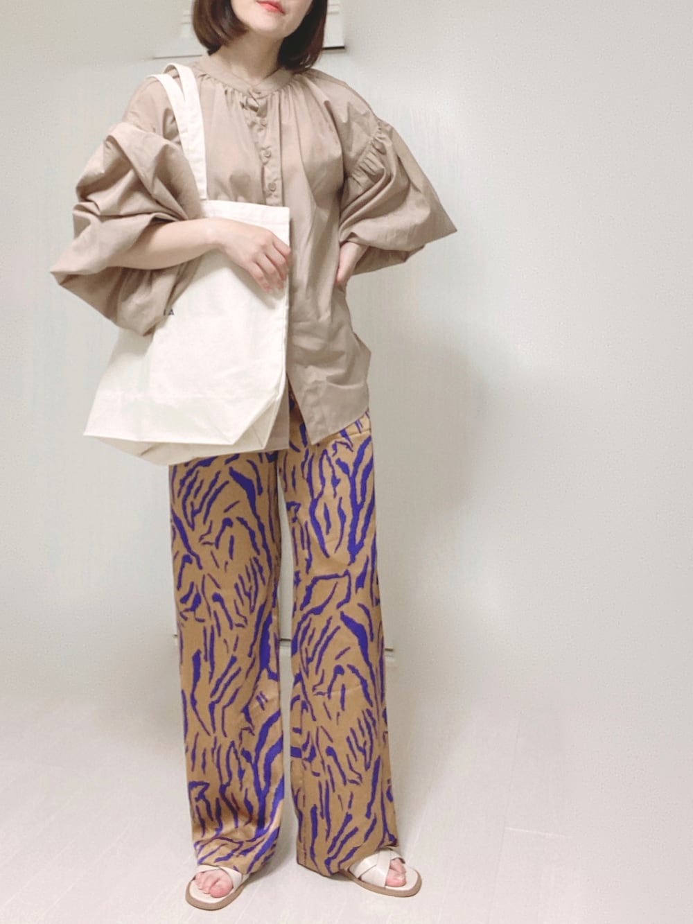 ホワイト系のトートバッグ、ベージュ系のシャツ/ブラウス、オレンジ系のその他パンツを着用したレディースの夏コーディネートの4枚目の写真