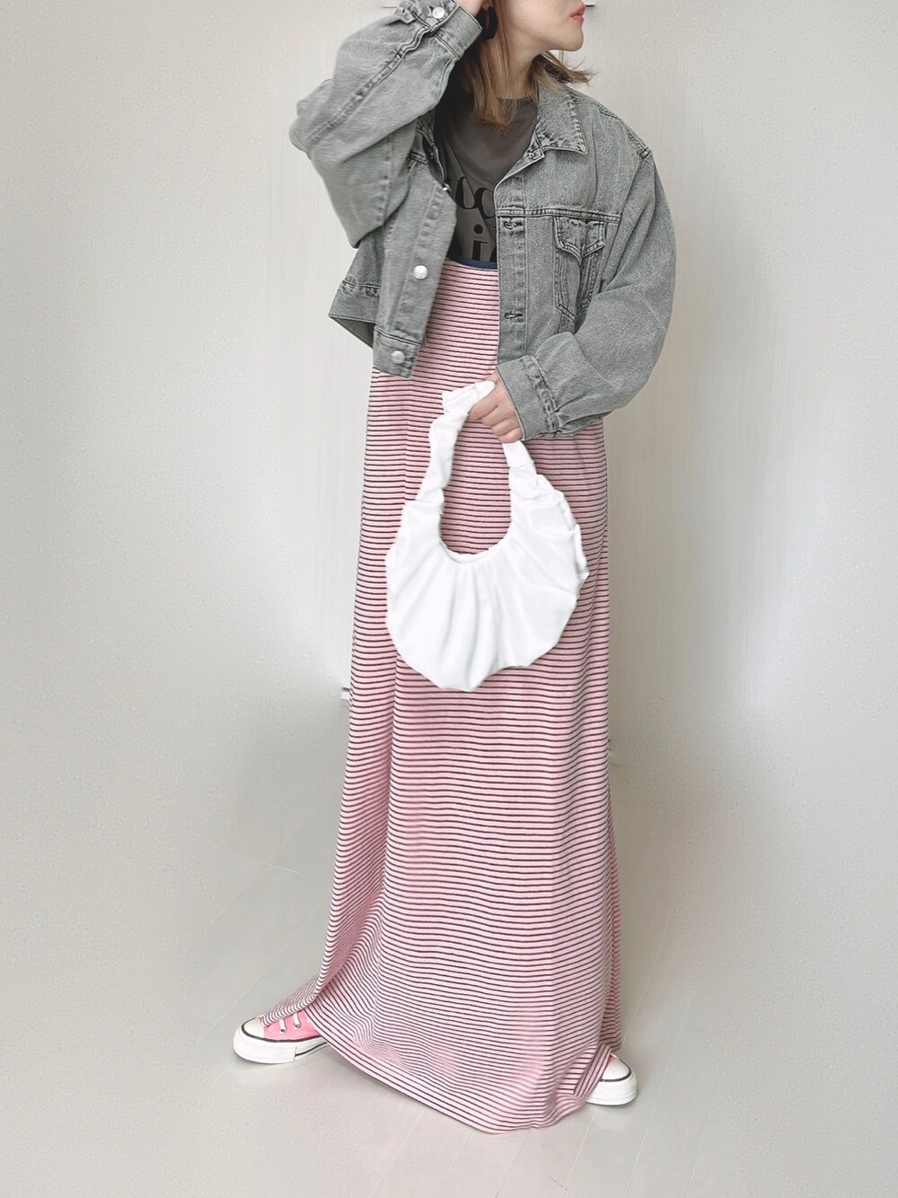 ピンク系のワンピース、ブラック系のデニムジャケット、ピンク系のスニーカーを着用したレディースの秋コーディネートの5枚目の写真