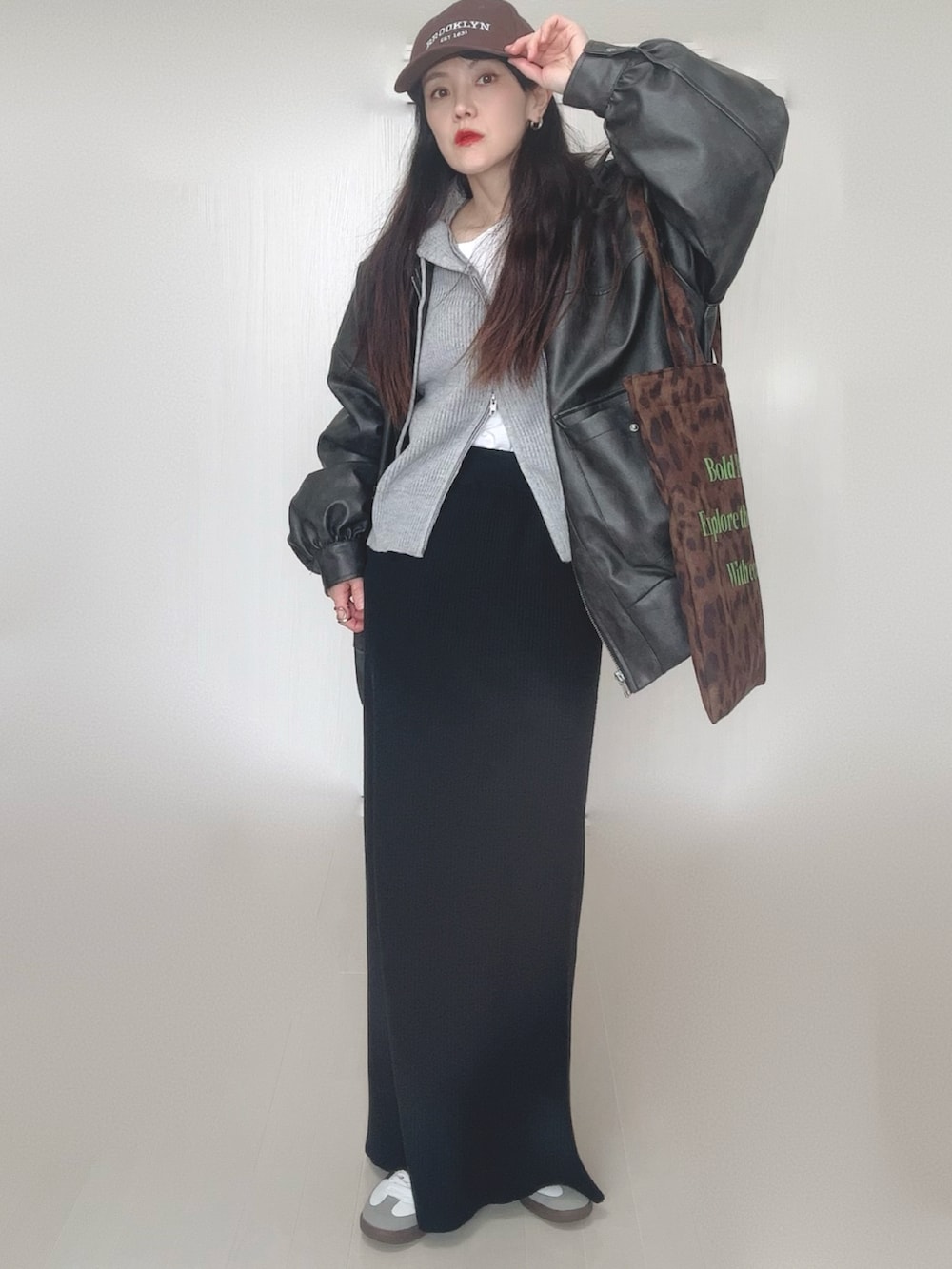 グレー系のパーカー、ブラック系のブルゾン、ブラウン系のトートバッグを着用したレディースの冬コーディネートの5枚目の写真