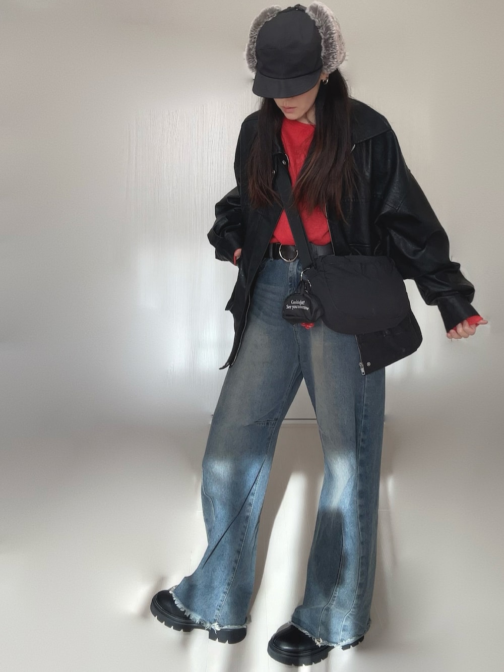 ブラック系のブルゾン、レッド系のTシャツ/カットソー、ブラック系のブーツを着用したレディースの冬コーディネートの3枚目の写真