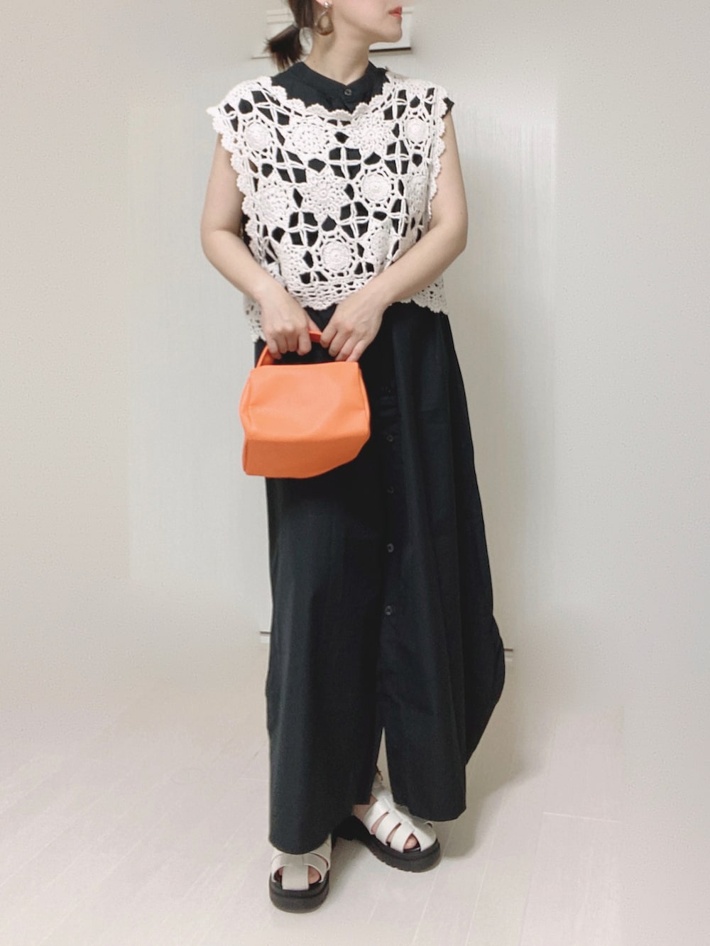 ブラック系のワンピース、オレンジ系のショルダーバッグを着用したレディースの夏コーディネートの4枚目の写真