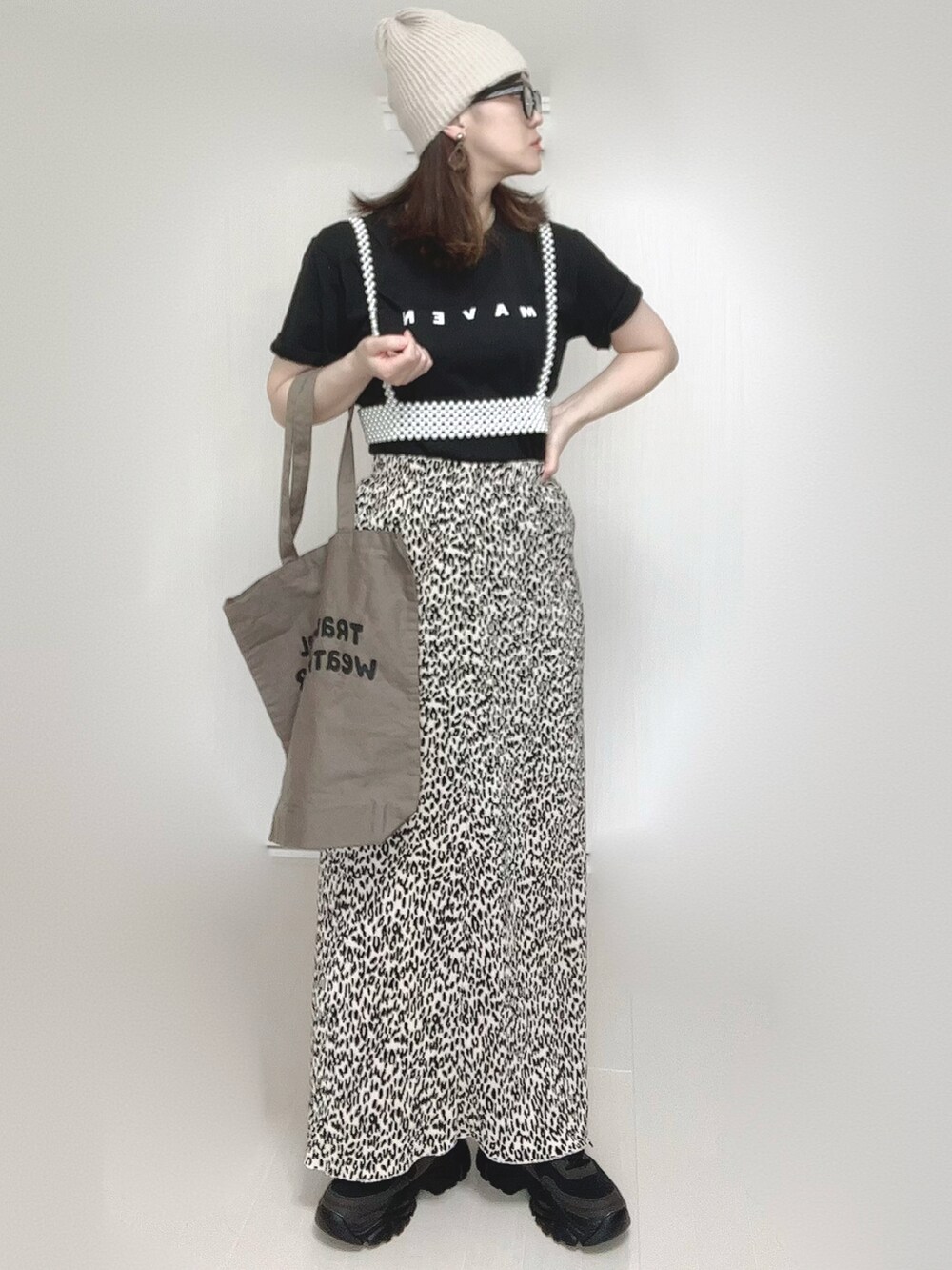 ベージュ系のスカート、ブラック系のTシャツ/カットソー、ブラック系のスニーカーを着用したレディースの春コーディネートの5枚目の写真