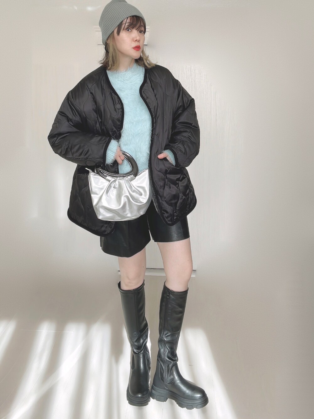 ブルー系のニット/セーター、ブラック系のブーツ、グレー系のノーカラージャケットを着用したレディースの秋コーディネートの5枚目の写真