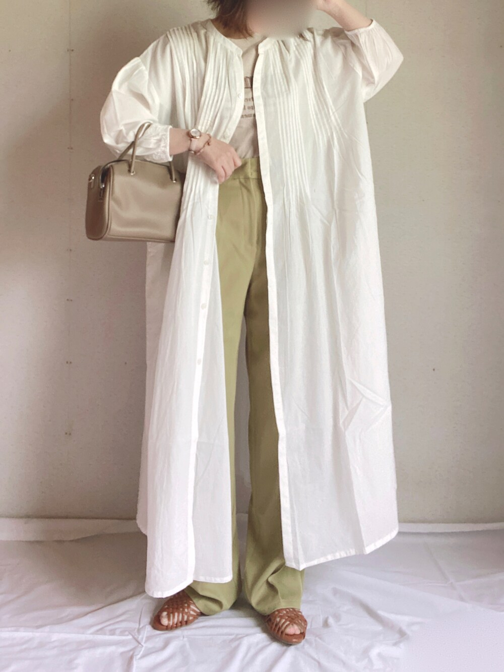 グリーン系のスラックス、ホワイト系のシャツワンピース、ブラウン系のサンダルを着用したレディースの夏コーディネートの3枚目の写真