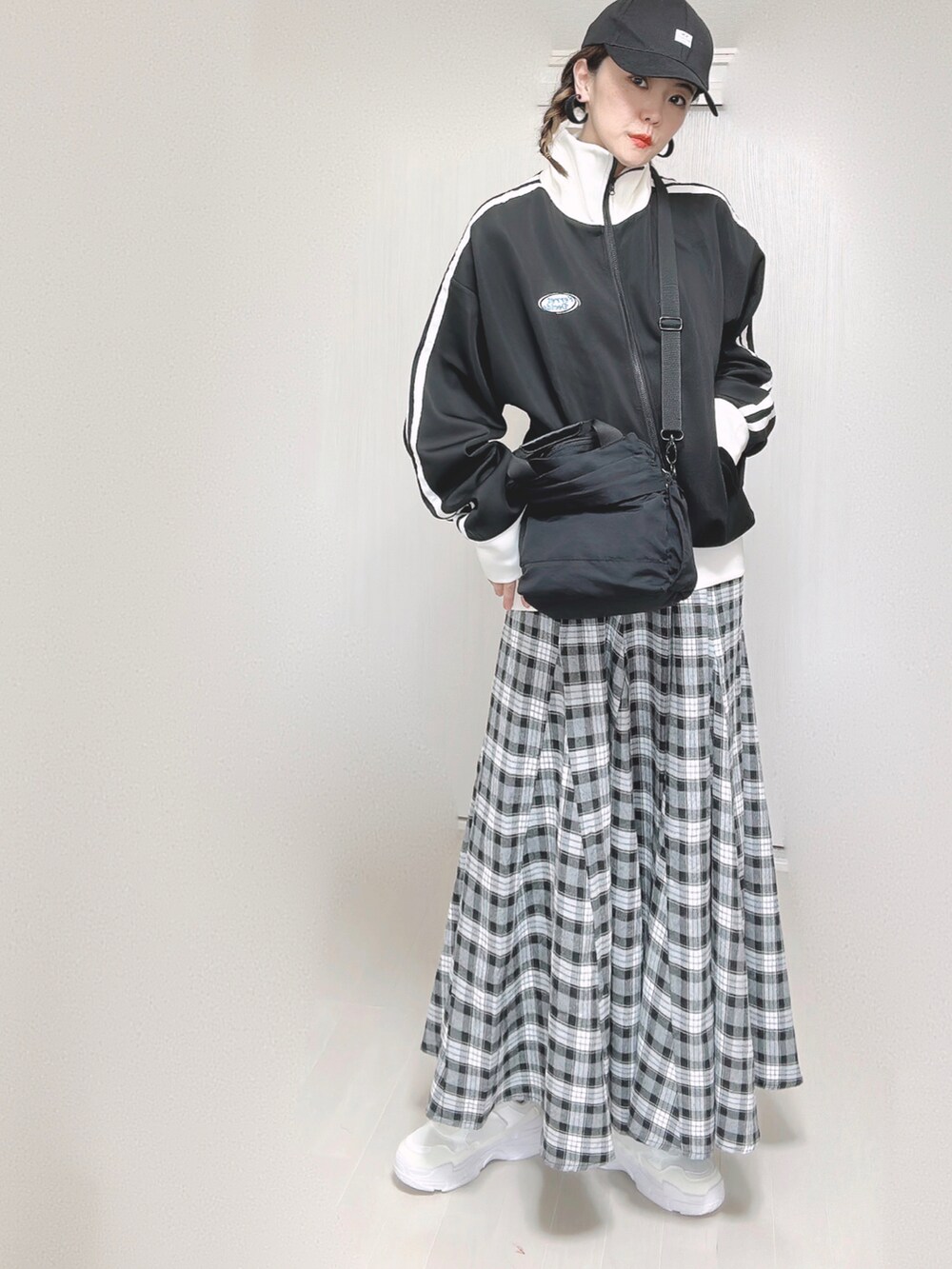 ブラック系のブルゾン、ブラック系のショルダーバッグ、ブラック系のスカートを着用したレディースの秋コーディネートの4枚目の写真