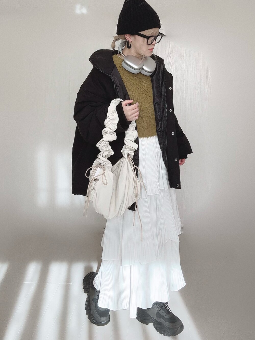 ブラック系のブルゾン、グリーン系のニット/セーター、ホワイト系のスカートを着用したレディースの冬コーディネートの5枚目の写真