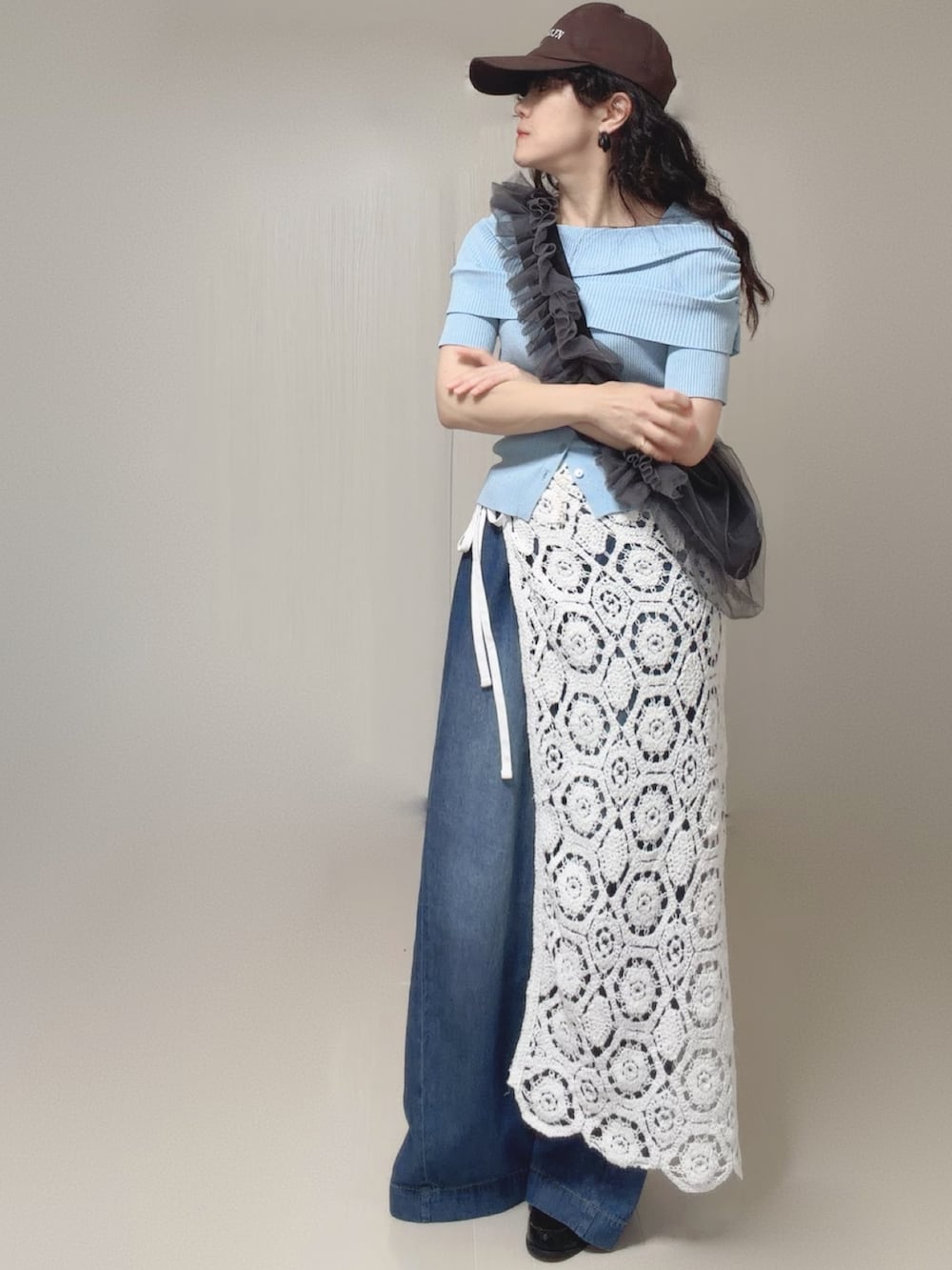 ブルー系のニット/セーター、ホワイト系のスカート、ブルー系のデニムパンツを着用したレディースの夏コーディネートの5枚目の写真