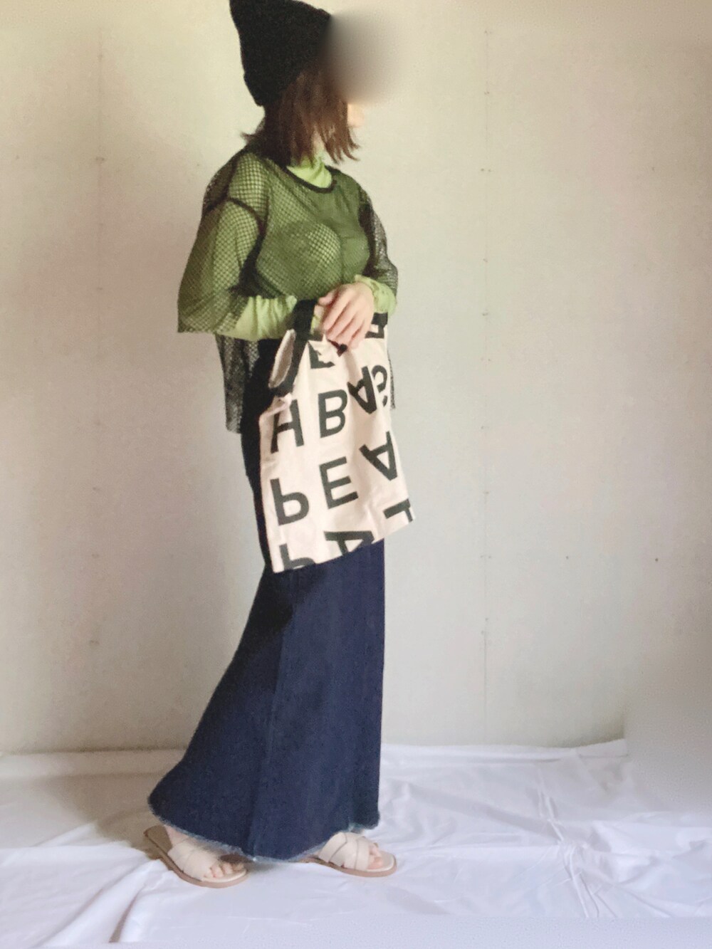 ブルー系のデニムスカート、ホワイト系のサンダル、グリーン系のTシャツ/カットソーを着用したレディースの秋コーディネートの2枚目の写真