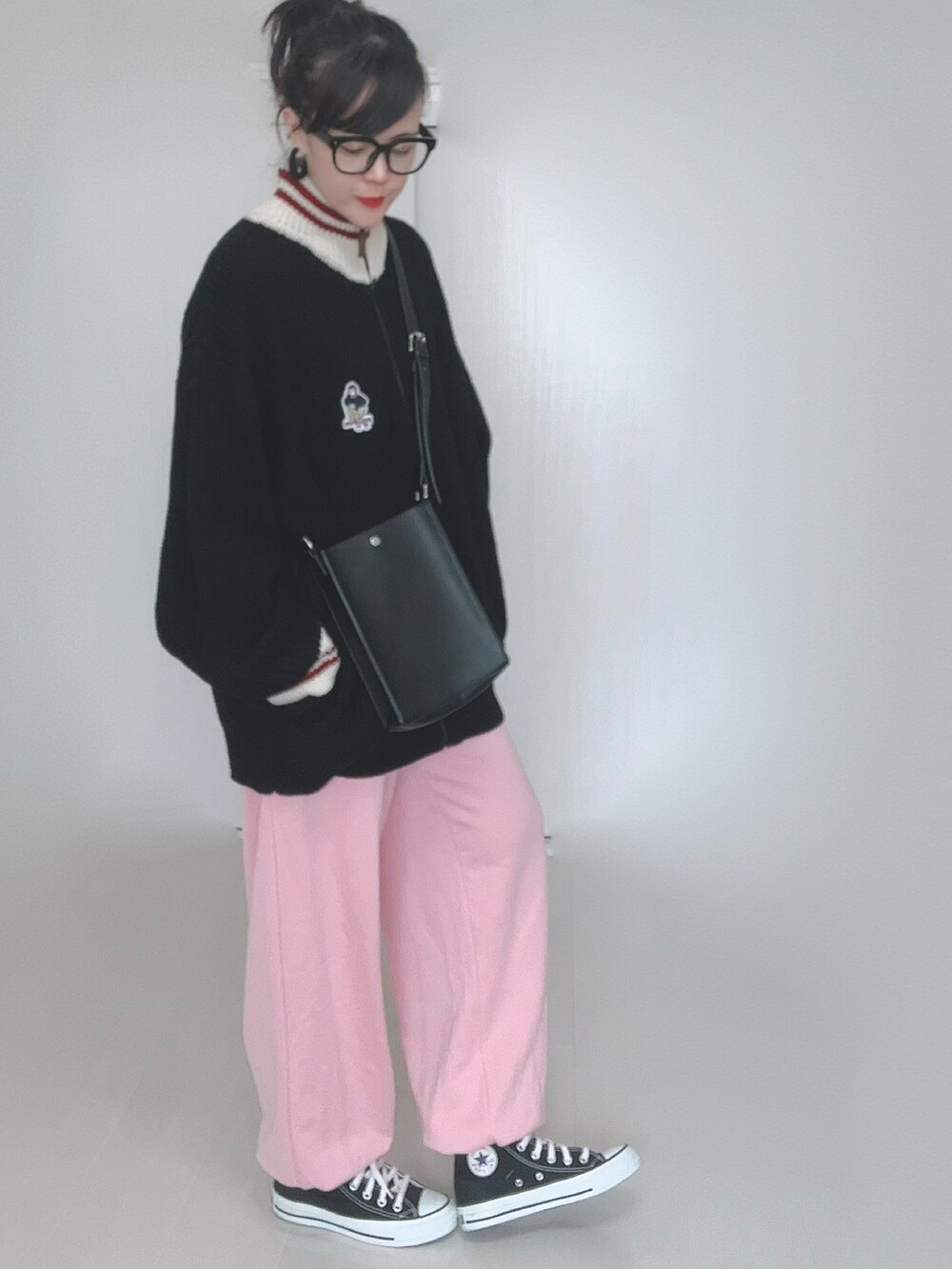 ブラック系のニット/セーター、ホワイト系のショルダーバッグ、シルバー系のスカートを着用したレディースの冬コーディネートの4枚目の写真