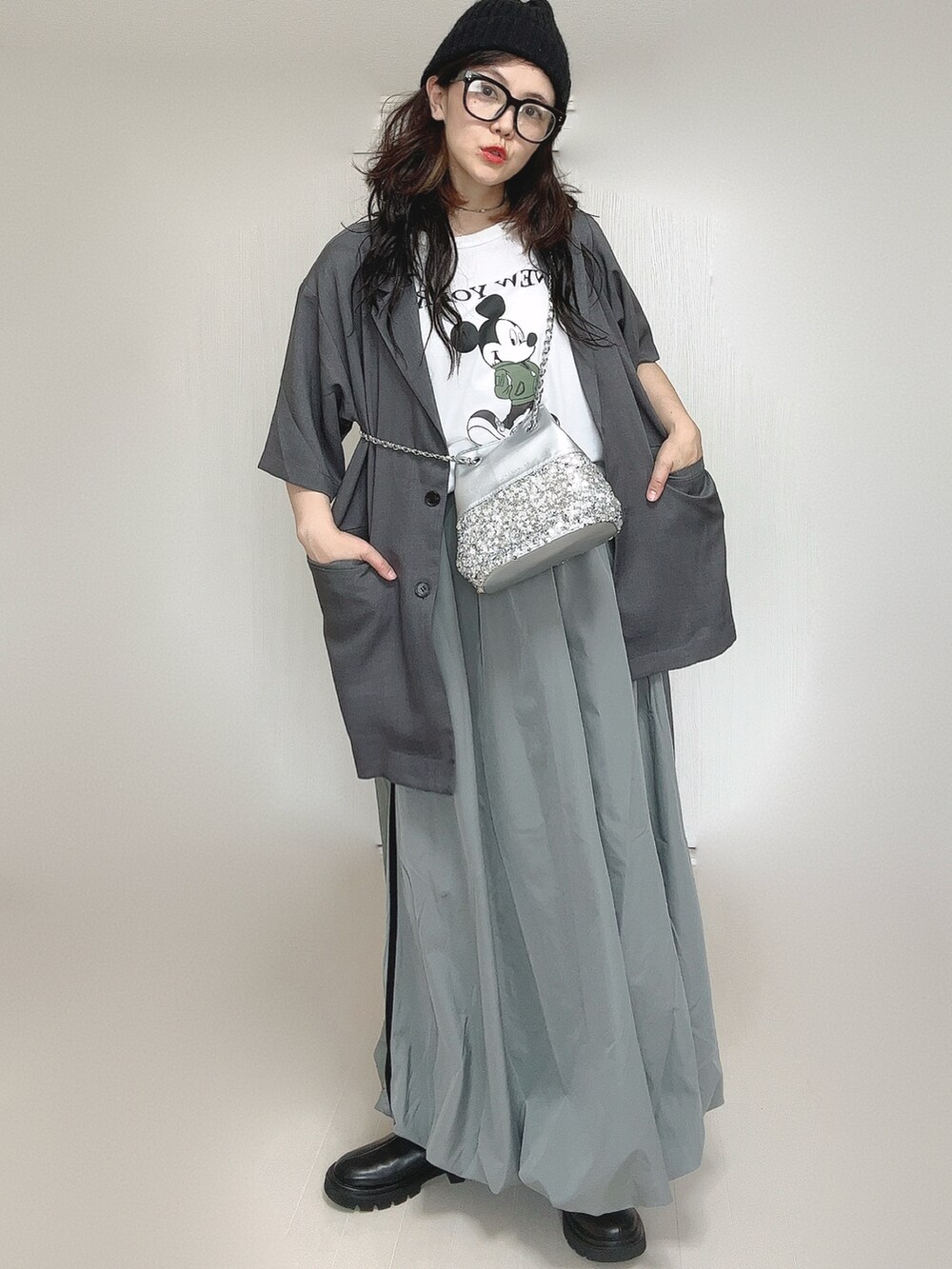 グレー系のテーラードジャケット、ブラック系のブーツ、ホワイト系のTシャツ/カットソーを着用したレディースの夏コーディネートの2枚目の写真