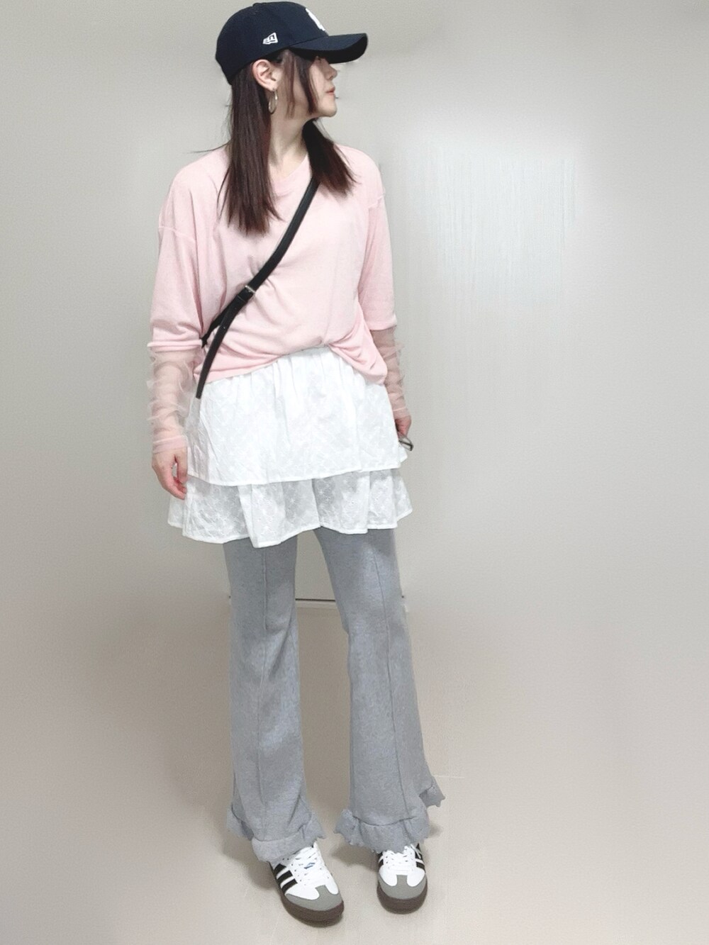 ホワイト系のスカート、ピンク系のTシャツ/カットソー、ブラック系のショルダーバッグを着用したレディースの春コーディネートの2枚目の写真