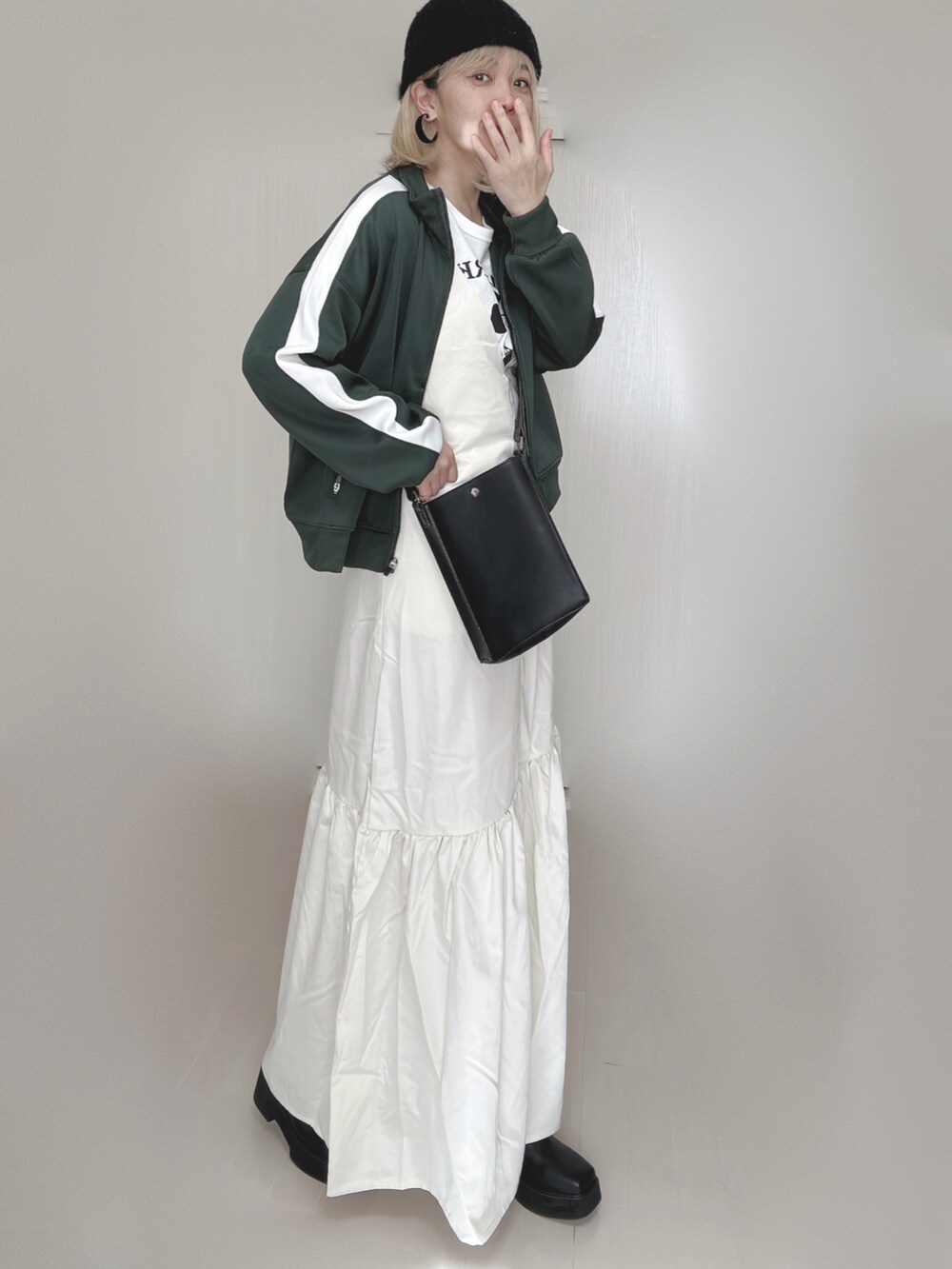 ホワイト系のジャンパースカート、グリーン系のその他アウター、ホワイト系のTシャツ/カットソーを着用したレディースの秋コーディネートの5枚目の写真