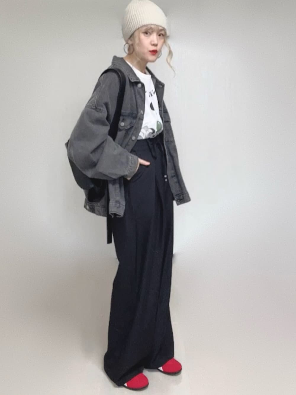 ブラック系のデニムジャケット、ブラック系のスラックス、ホワイト系のTシャツ/カットソーを着用したレディースの冬コーディネートの4枚目の写真