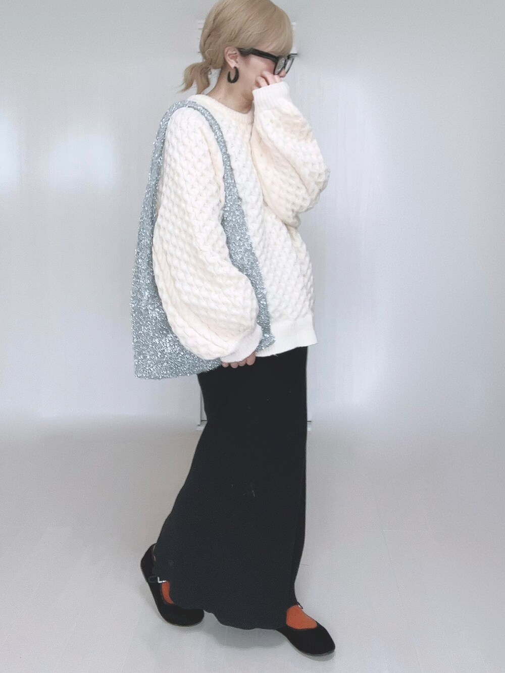 ホワイト系のニット/セーター、ブラック系のスカート、ブラック系のパンプスを着用したレディースの冬コーディネートの3枚目の写真