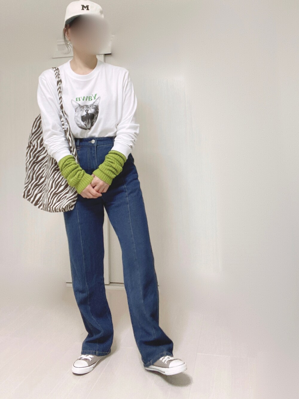 ホワイト系のTシャツ/カットソー、ブルー系のデニムパンツ、グリーン系のアームカバーを着用したレディースの秋コーディネートの5枚目の写真