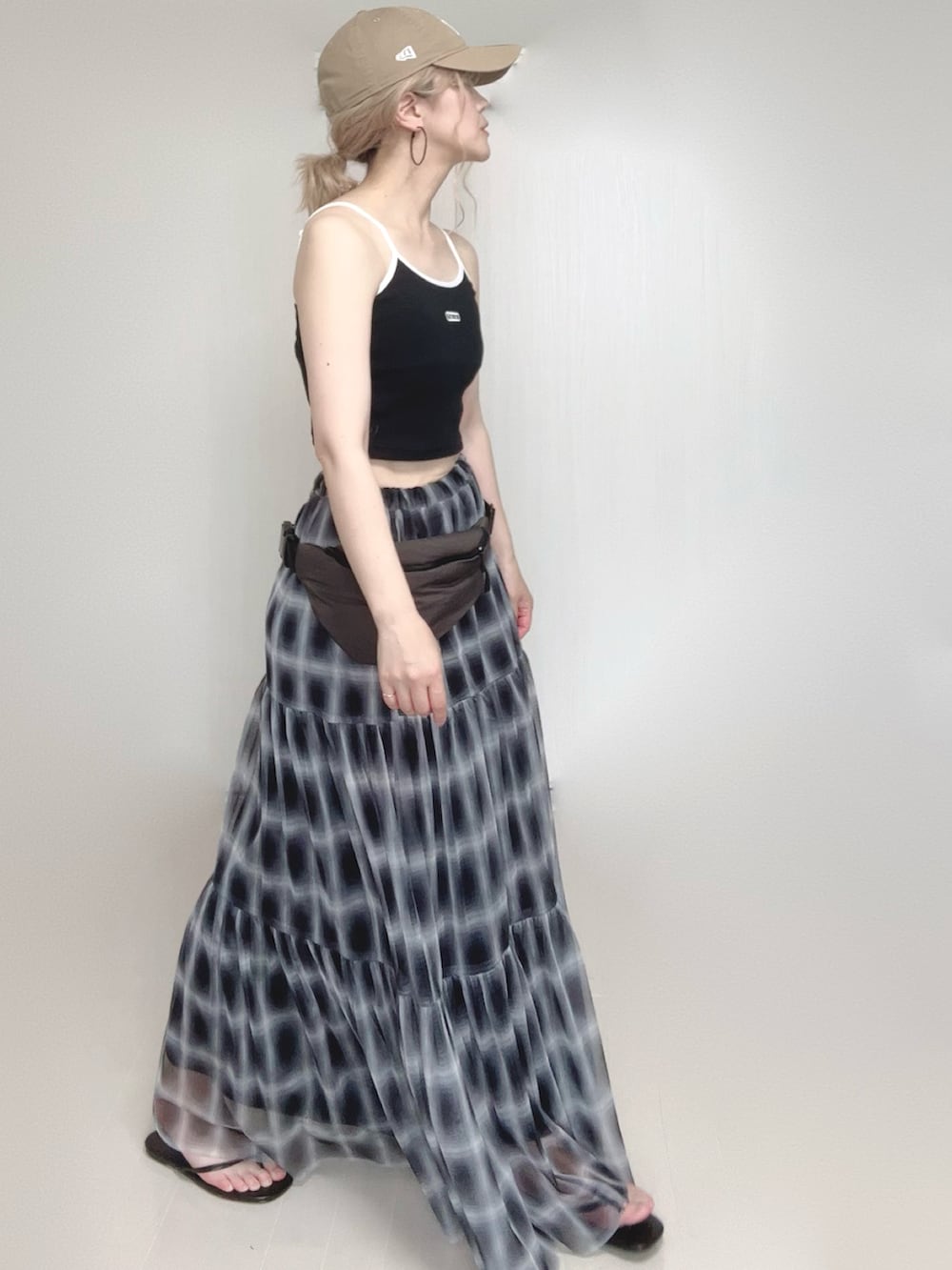 ブラック系のスカート、ブラック系のキャミソール、ブラック系のサンダルを着用したレディースの夏コーディネートの4枚目の写真