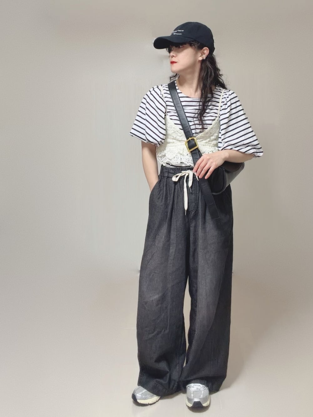 ホワイト系のキャミソール、ブラック系のTシャツ/カットソー、ブラック系のデニムパンツを着用したレディースの夏コーディネートの3枚目の写真