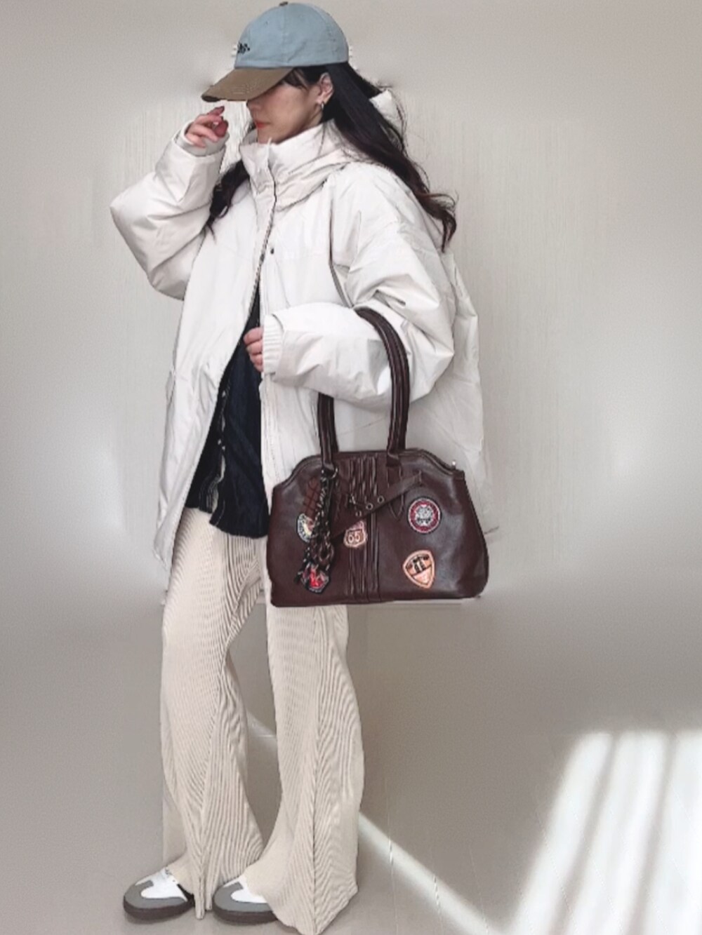 ホワイト系のブルゾン、ブラック系のシャツ/ブラウス、ホワイト系のその他パンツを着用したレディースの冬コーディネートの4枚目の写真