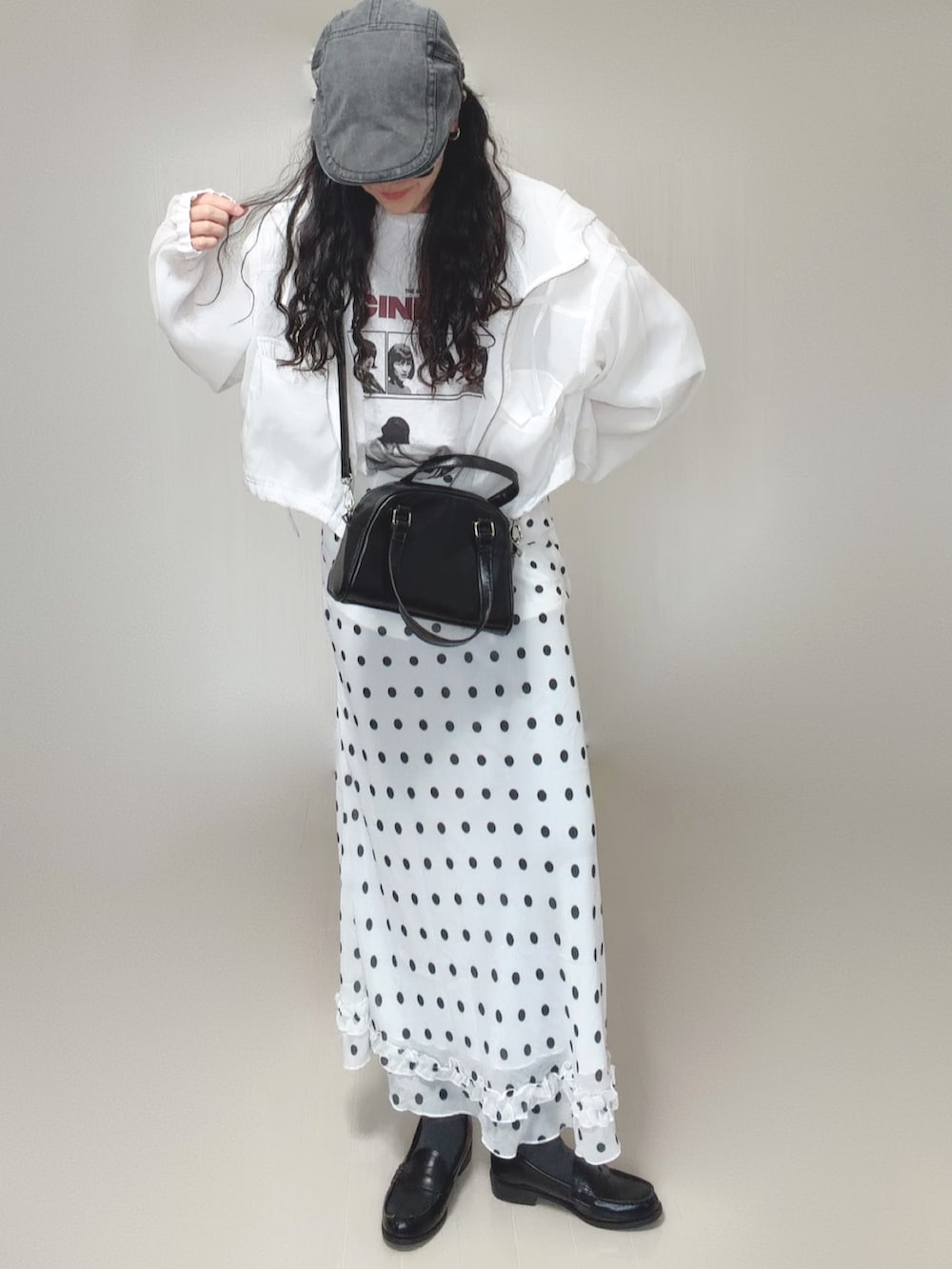 ホワイト系のマウンテンパーカー、ホワイト系のTシャツ/カットソー、ブラック系のボストンバッグを着用したレディースの春コーディネートの3枚目の写真