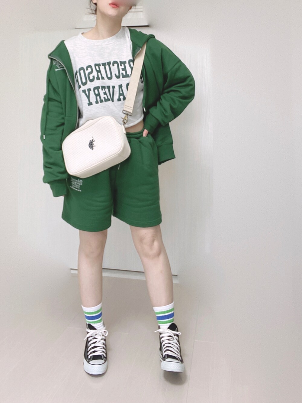 グリーン系のパーカー、グリーン系のその他パンツ、ホワイト系のショルダーバッグを着用したレディースの春コーディネートの2枚目の写真