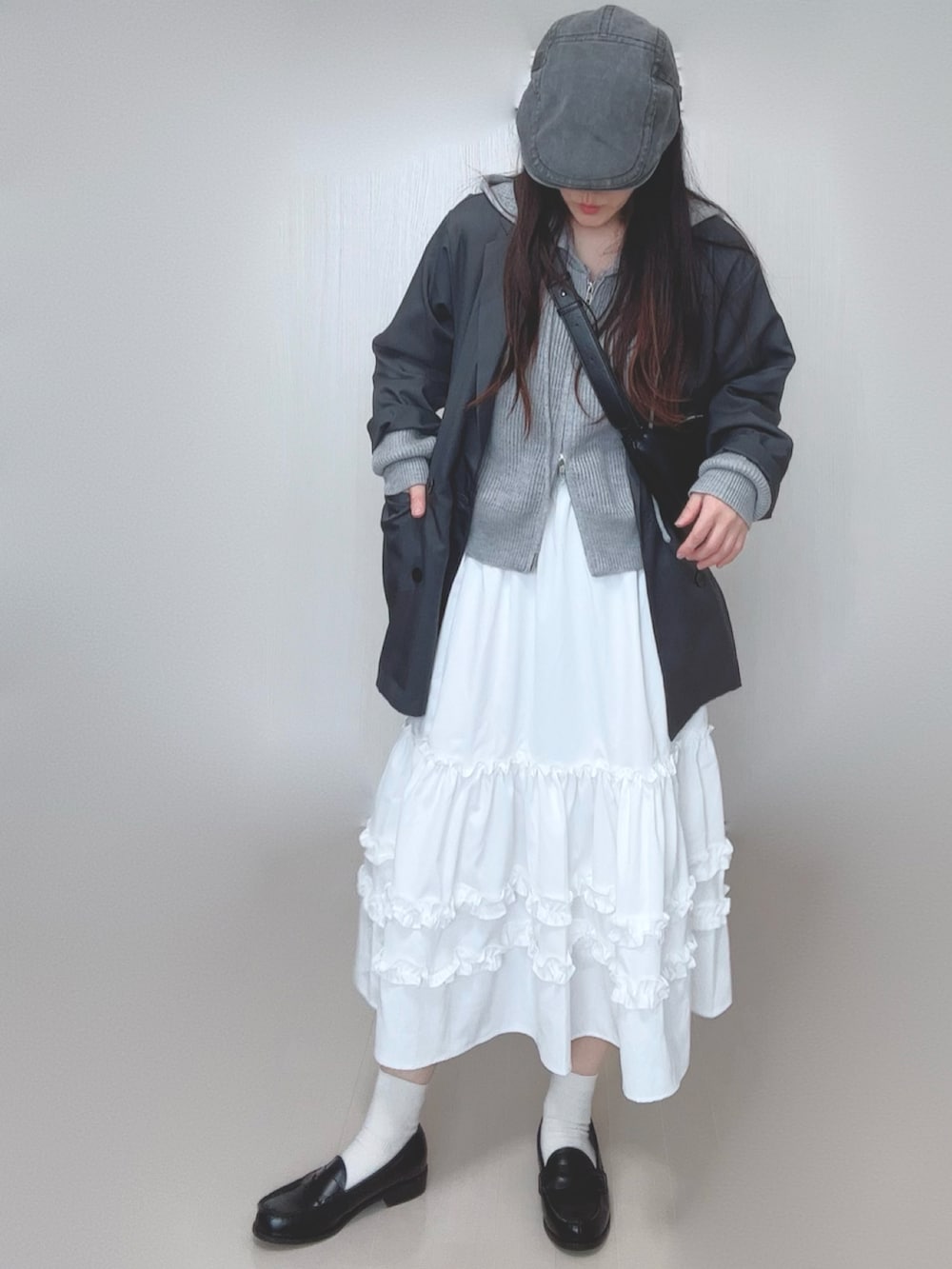 グレー系のパーカー、グレー系のテーラードジャケット、ホワイト系のスカートを着用したレディースの春コーディネートの4枚目の写真