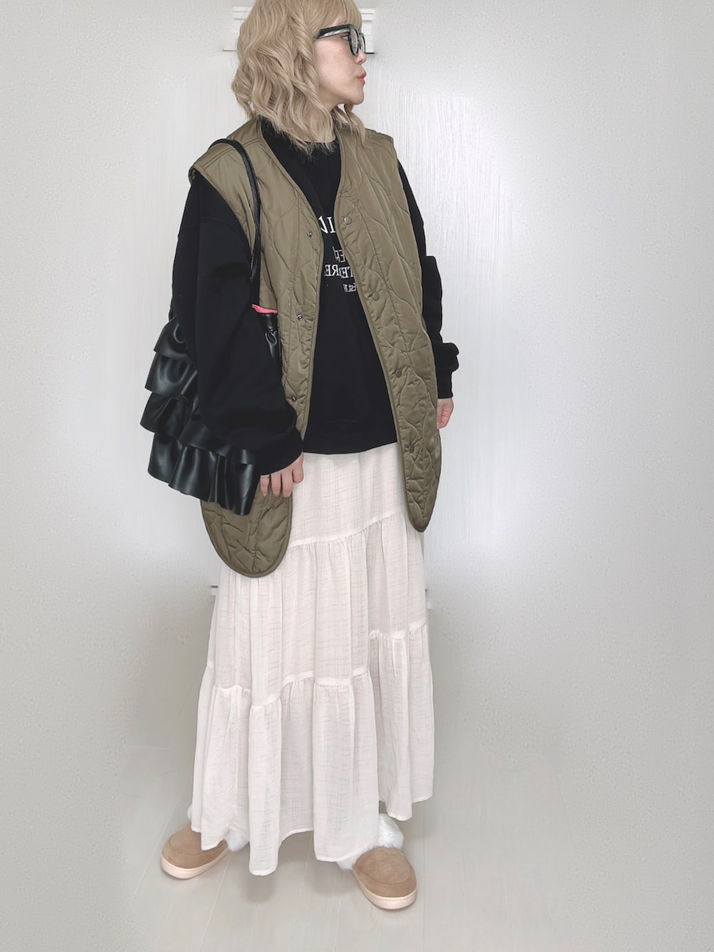 ブラック系のスウェット、ホワイト系のスカートを着用したレディースの秋コーディネートの3枚目の写真