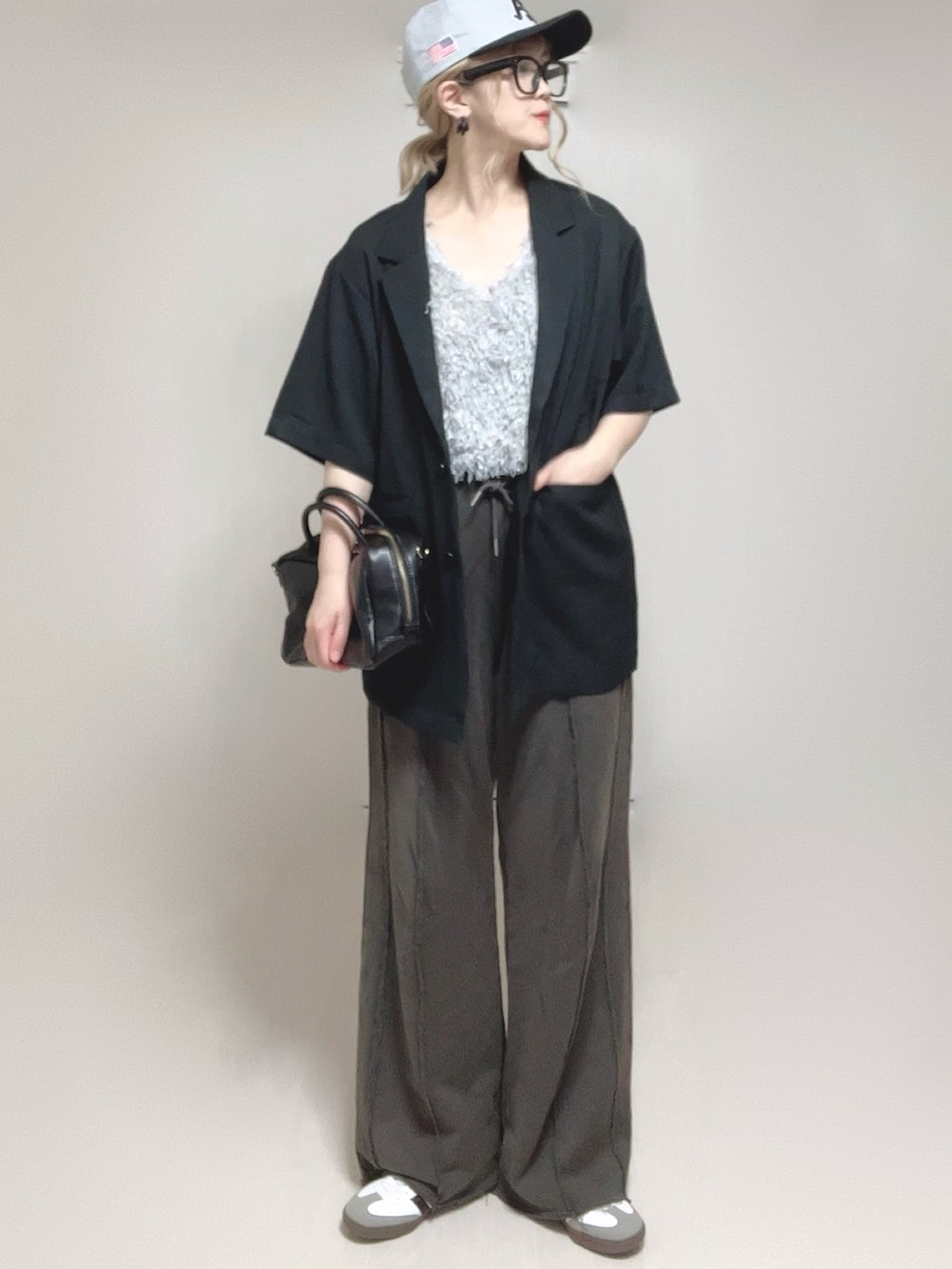 グレー系のベスト、ブラック系のテーラードジャケット、ブラック系のスウェットパンツを着用したレディースの夏コーディネートの3枚目の写真