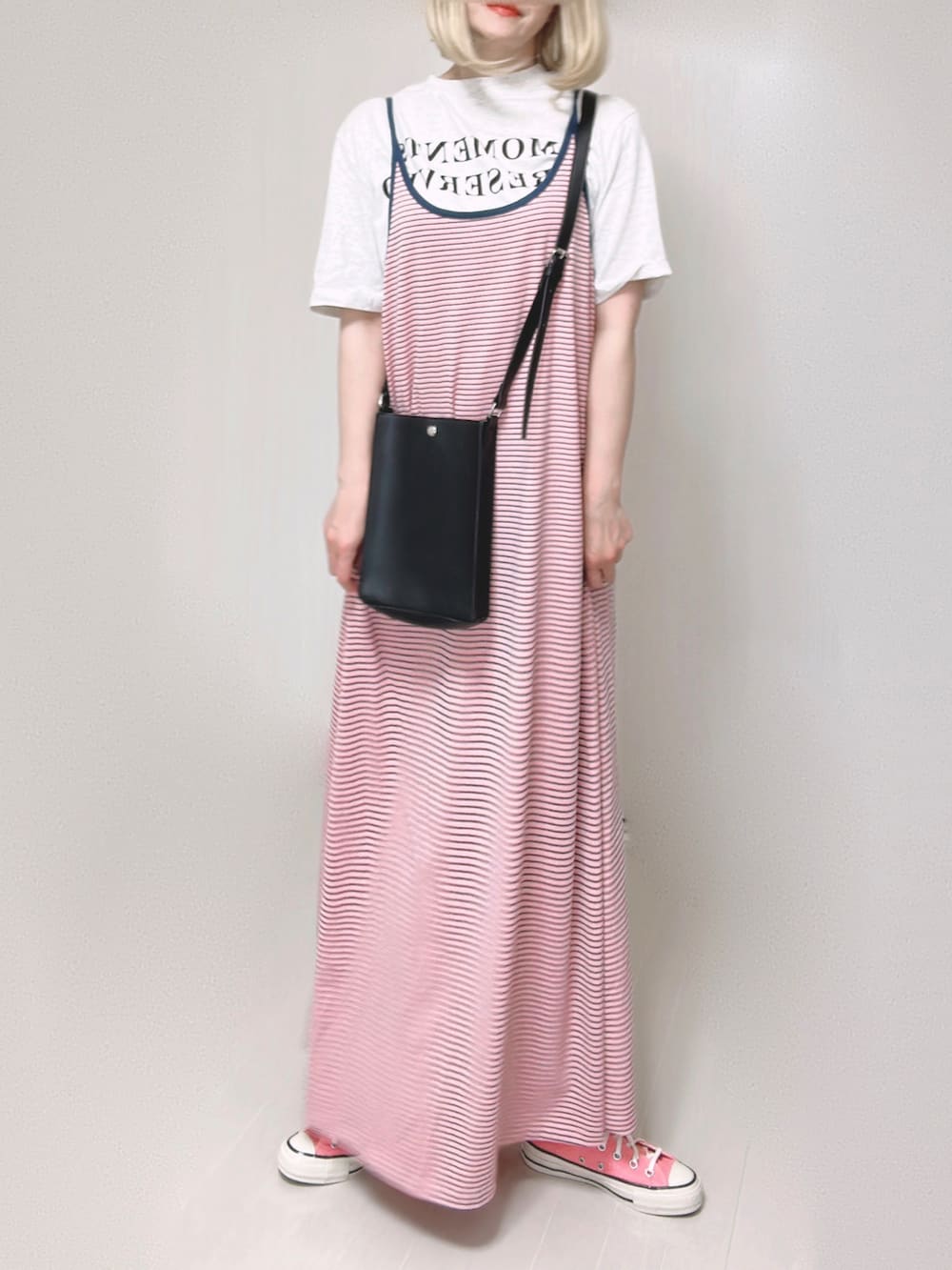 ピンク系のワンピース、ブラック系のショルダーバッグ、ピンク系のスニーカーを着用したレディースの夏コーディネートの4枚目の写真