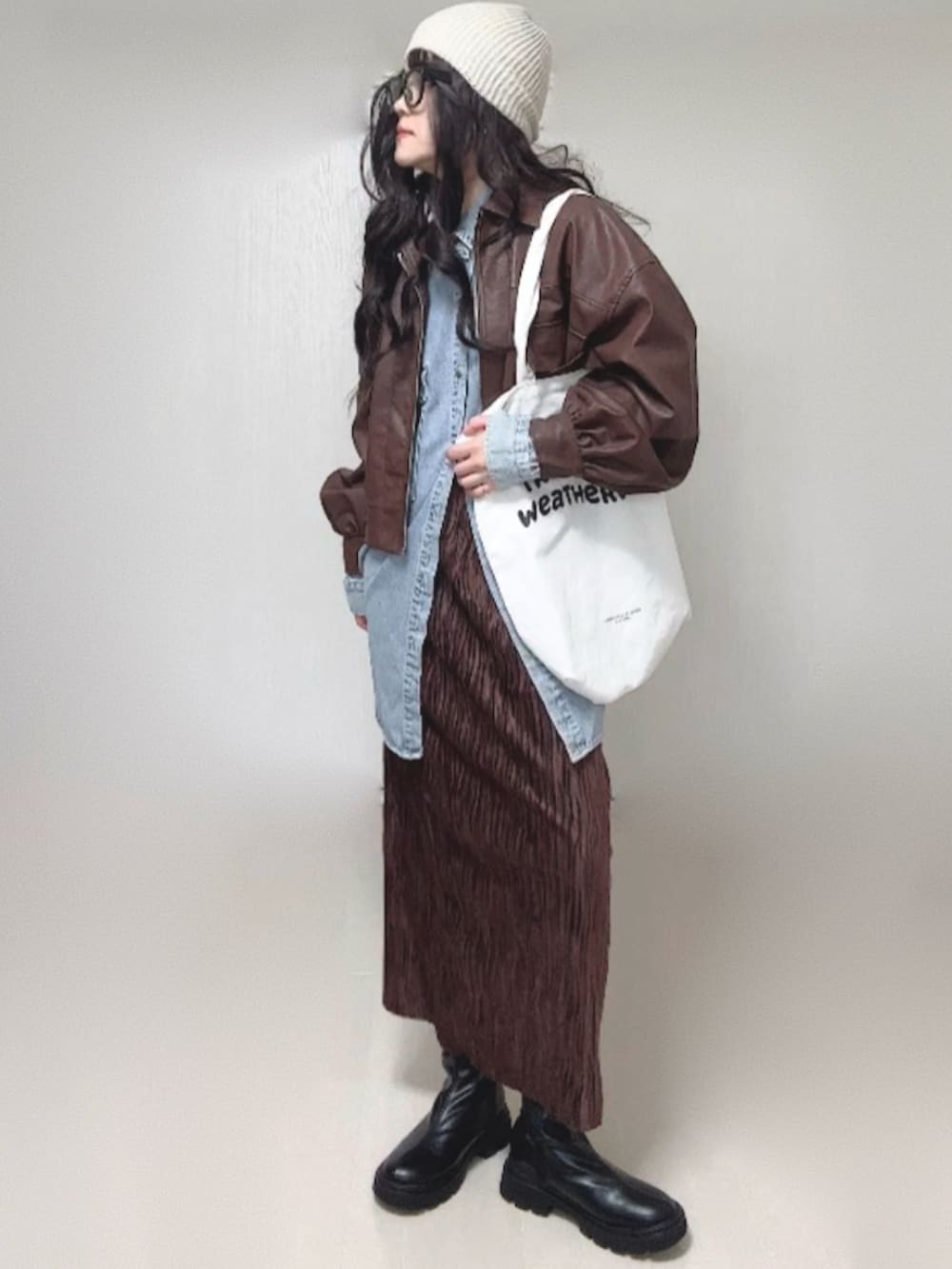 ブルー系のシャツ/ブラウス、ブラウン系のブルゾン、ブラック系のブーツを着用したレディースの冬コーディネートの5枚目の写真