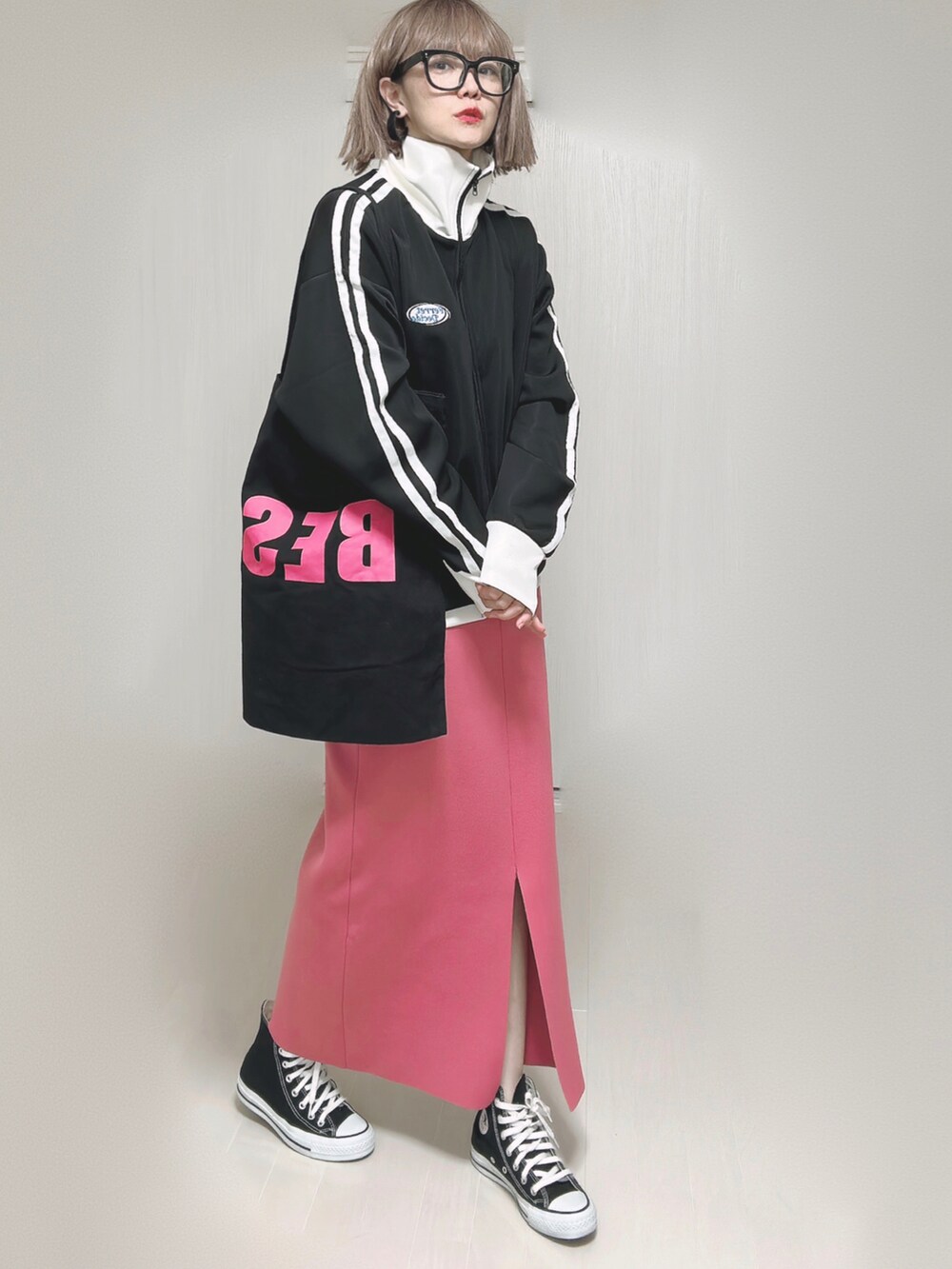 ブラック系のブルゾン、ブラック系のトートバッグ、ピンク系のスカートを着用したレディースの秋コーディネートの2枚目の写真