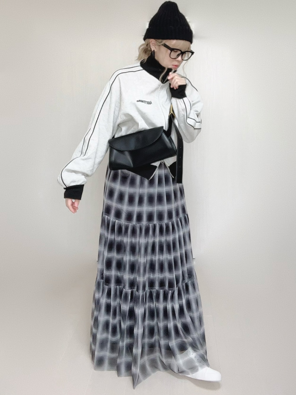 ブラック系のスカート、ベージュ系のジャージ、ホワイト系のスニーカーを着用したレディースの秋コーディネートの3枚目の写真