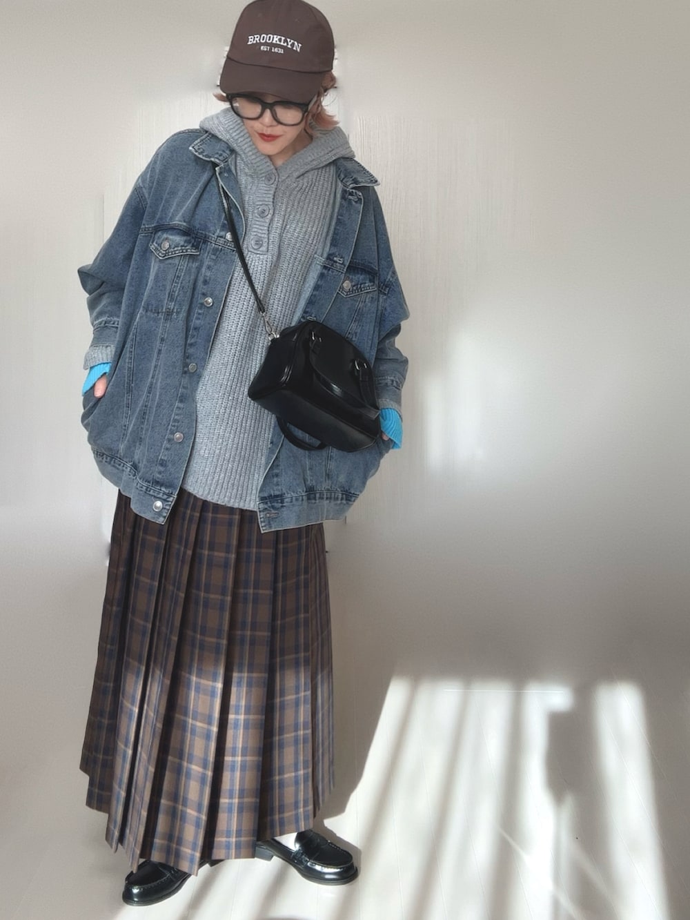 グレー系のニット/セーター、ブルー系のデニムジャケット、ブラウン系のスカートを着用したレディースの冬コーディネートの4枚目の写真