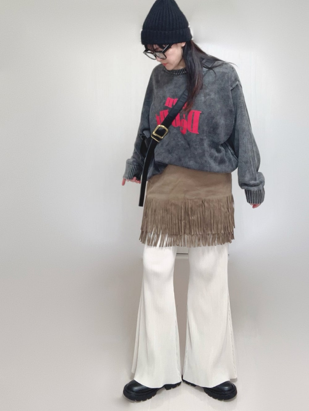 ブラック系のニット/セーター、ホワイト系のその他パンツ、ブラック系のブーツを着用したレディースの秋コーディネートの3枚目の写真