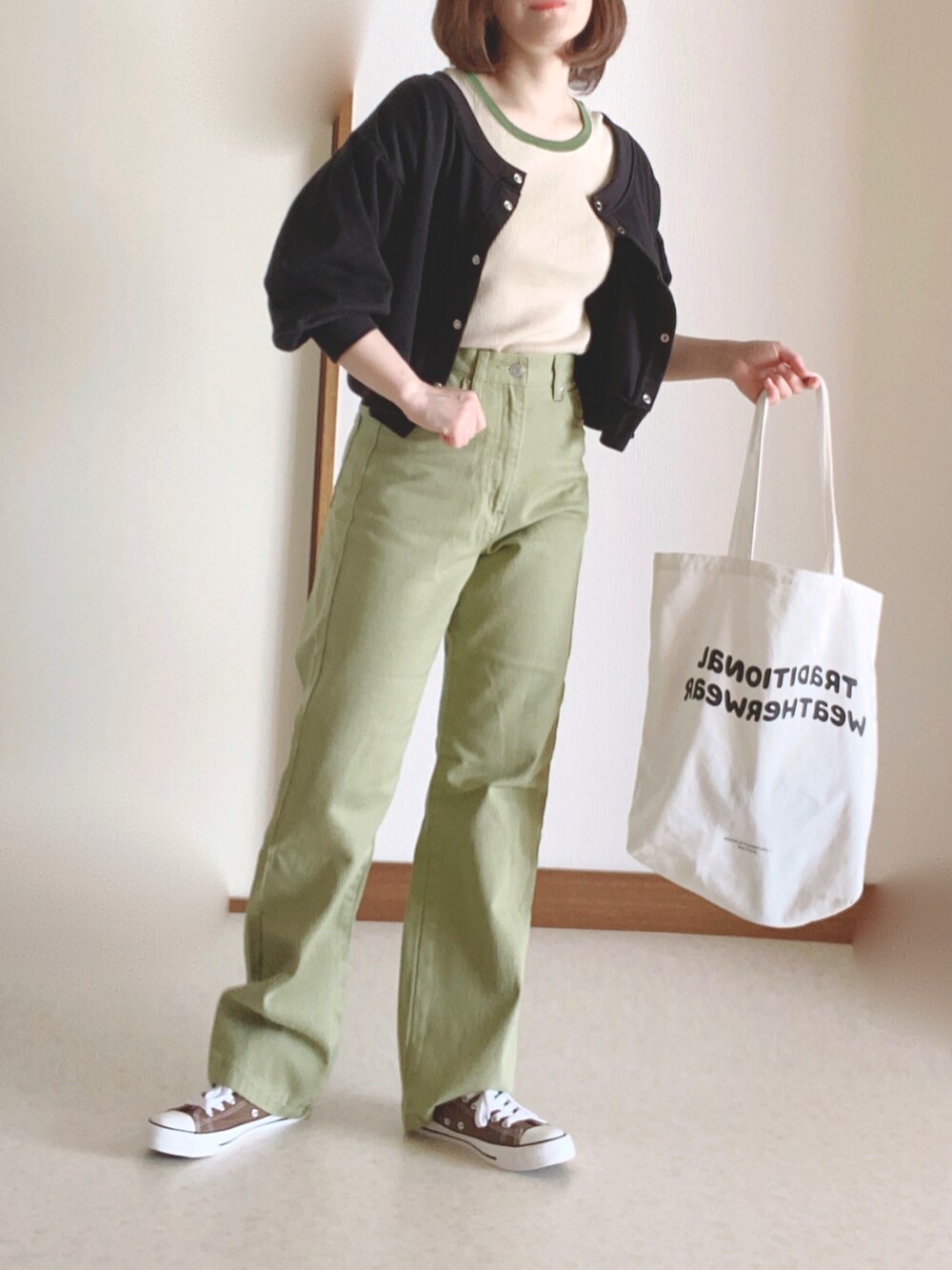 ホワイト系のトートバッグ、グリーン系のTシャツ/カットソー、グリーン系のデニムパンツを着用したレディースの秋コーディネートの2枚目の写真