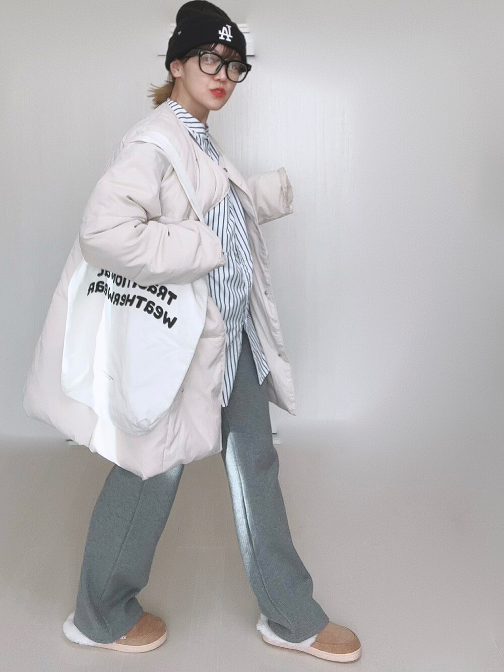 ホワイト系のダウンジャケット/コート、ホワイト系のシャツ/ブラウス、ホワイト系のトートバッグを着用したレディースの冬コーディネートの4枚目の写真